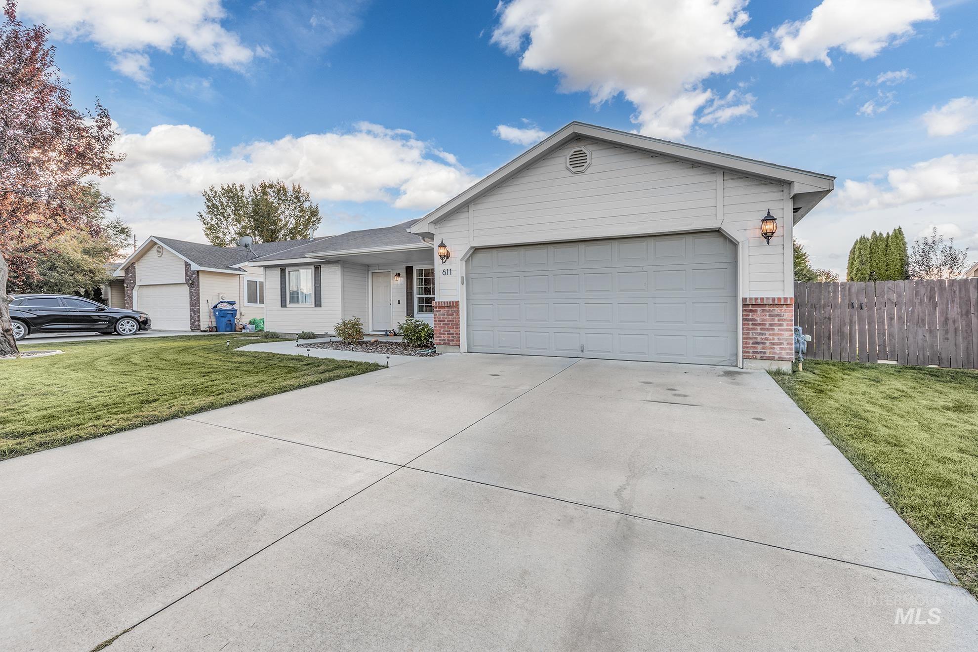 Ranch-style home featuring brick siding, driveway, and an attached garage