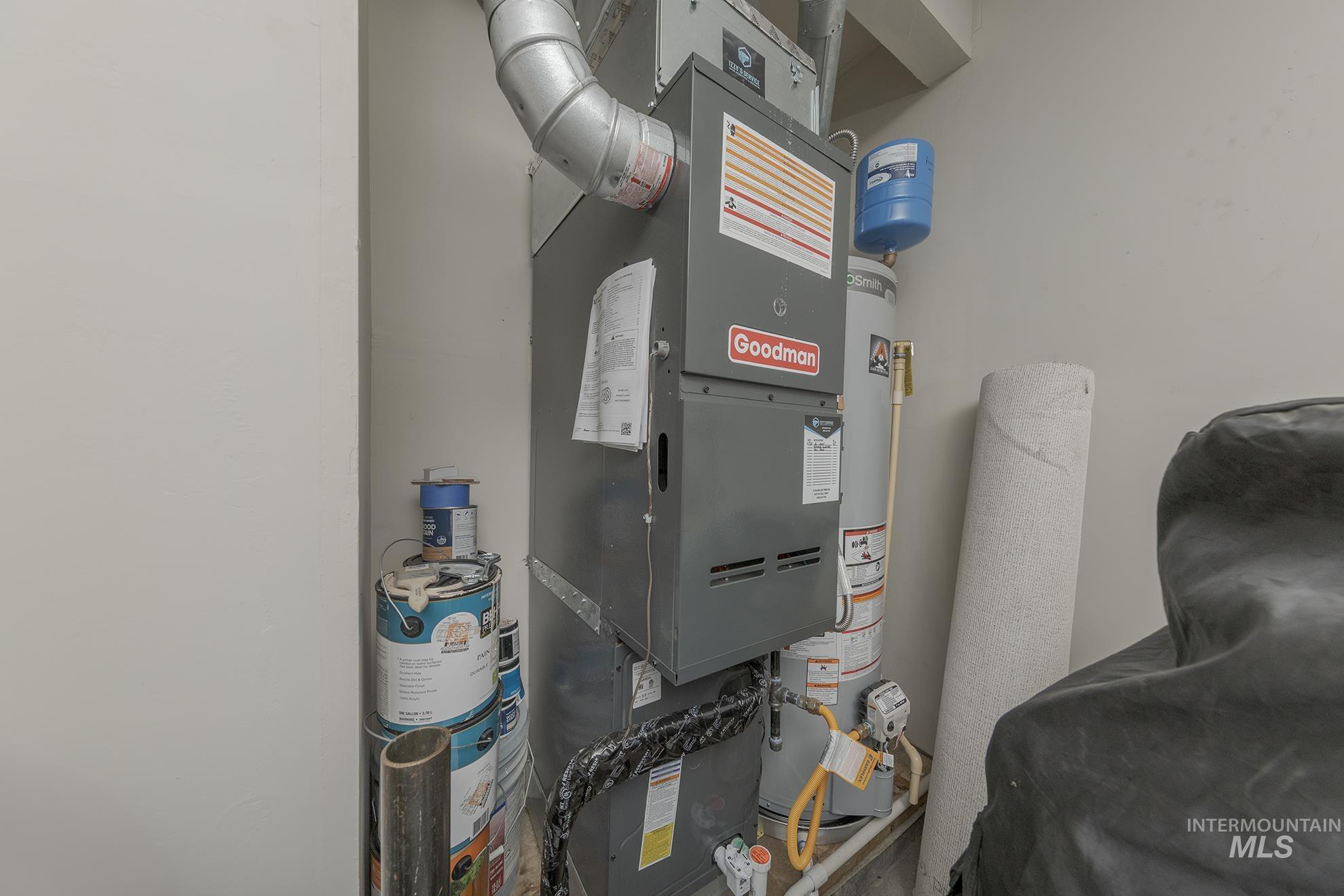 Utility room featuring heating unit and gas water heater