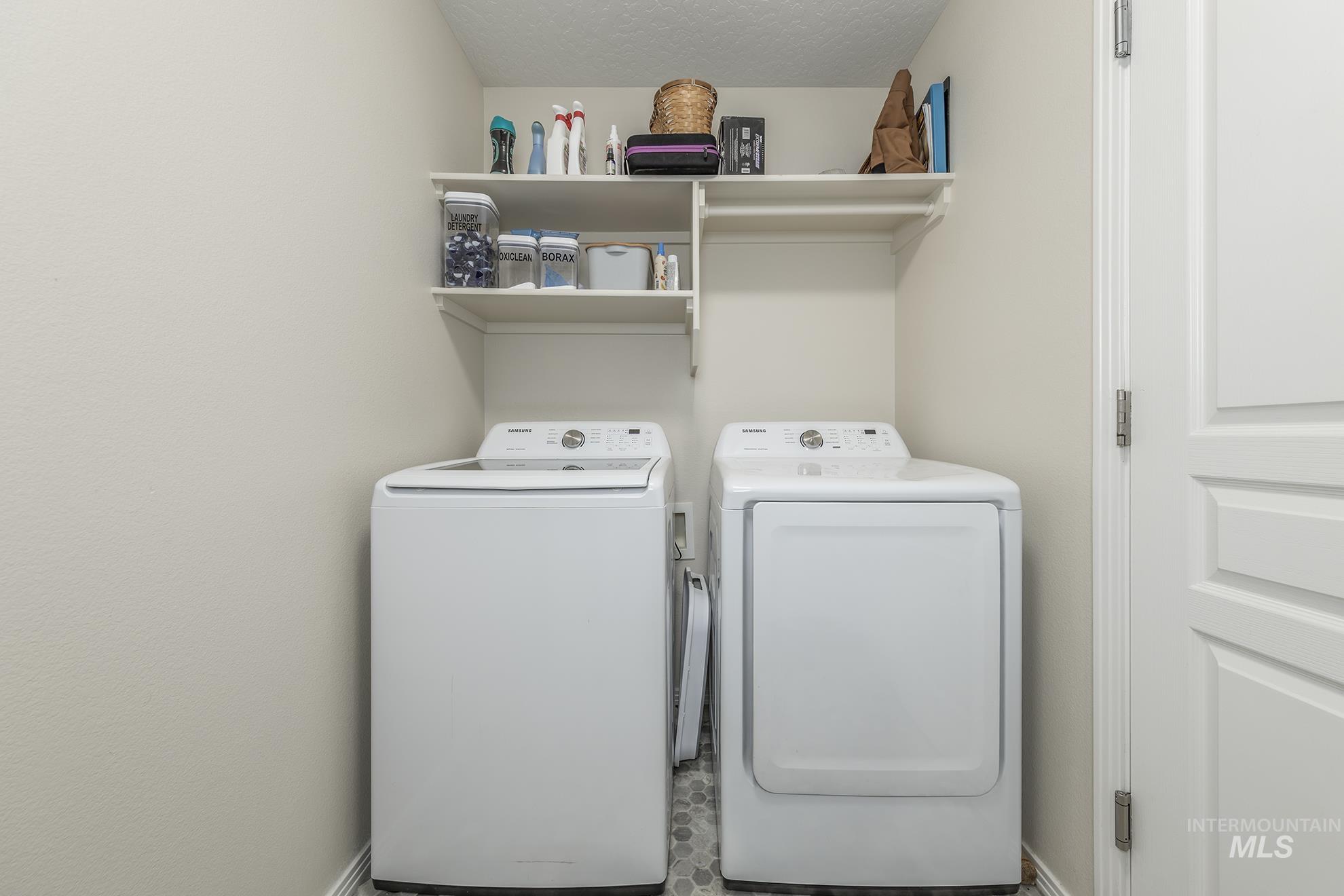 Laundry room with separate washer and dryer and a textured ceiling