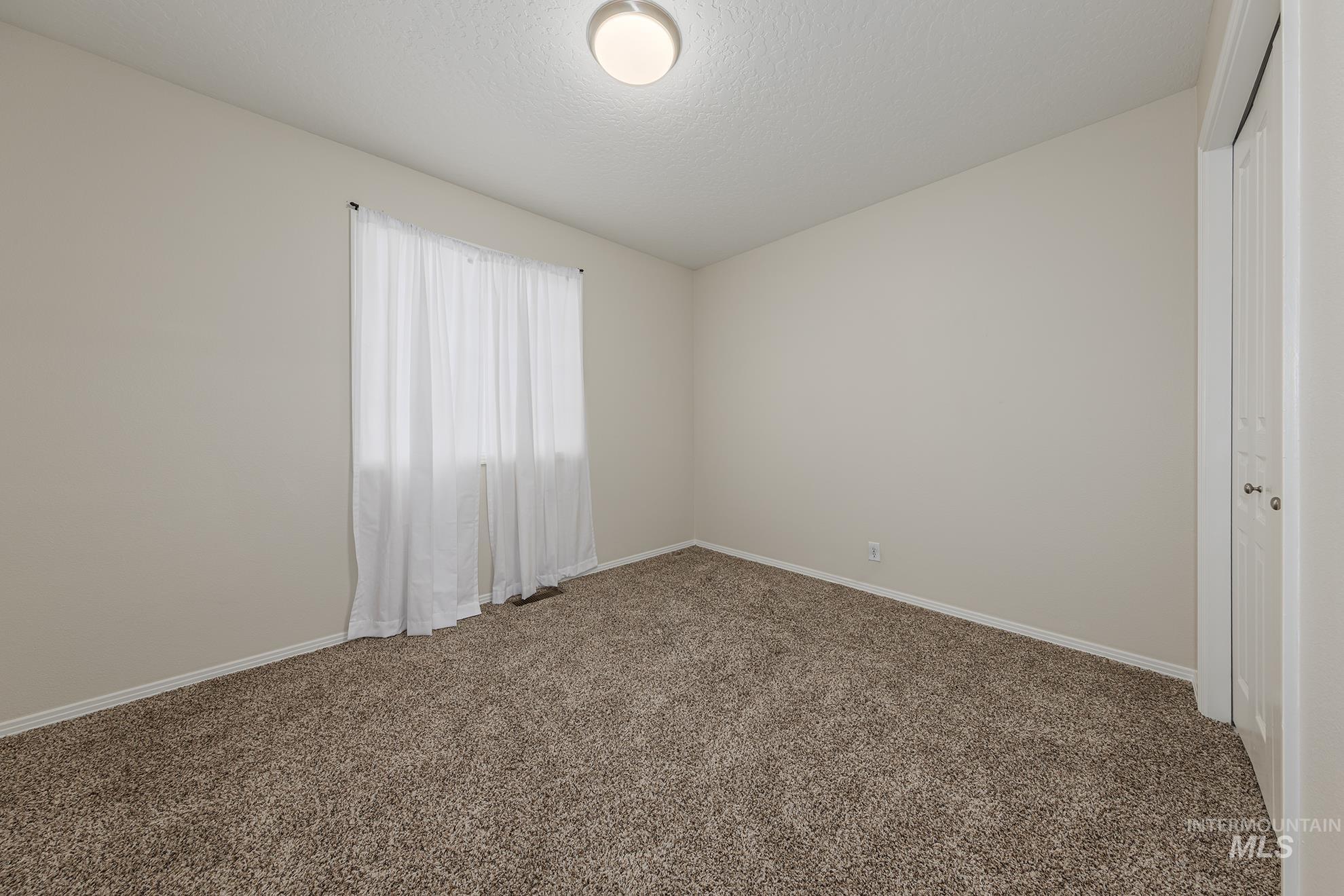 Spare room with carpet flooring and a textured ceiling