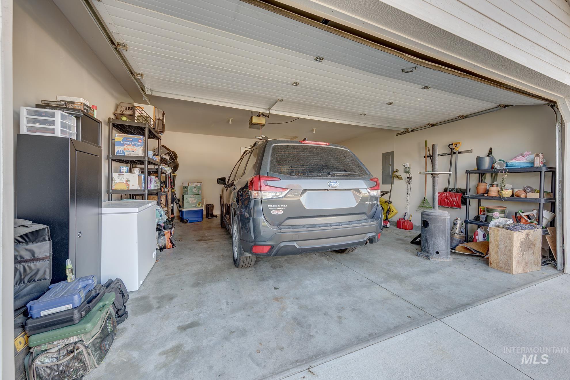 Garage with white refrigerator and electric panel