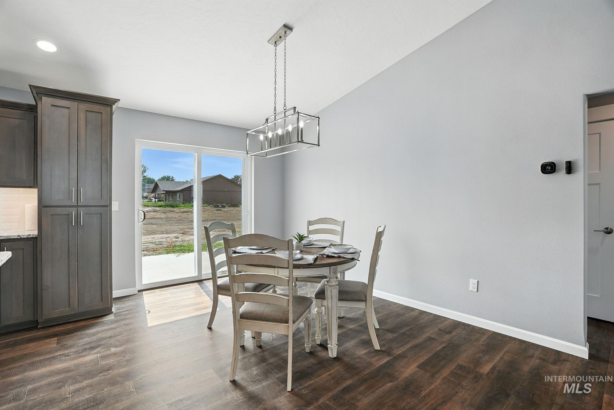 Dining area with dark wood finished floors, a chandelier, and recessed lighting