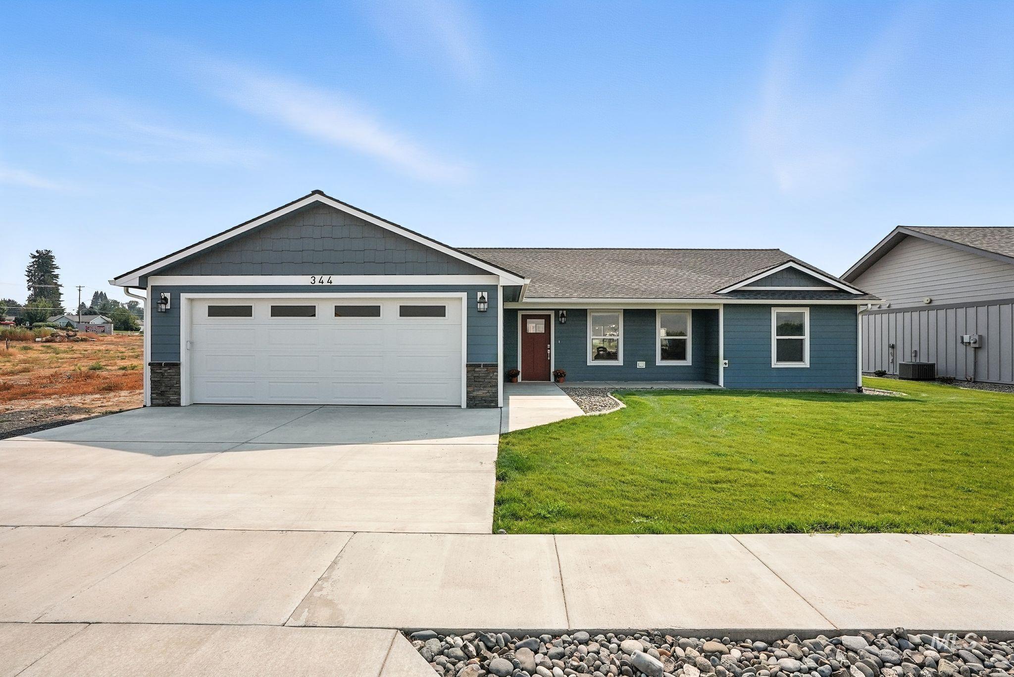 Single story home with concrete driveway, an attached garage, a front yard, a shingled roof, and stone siding