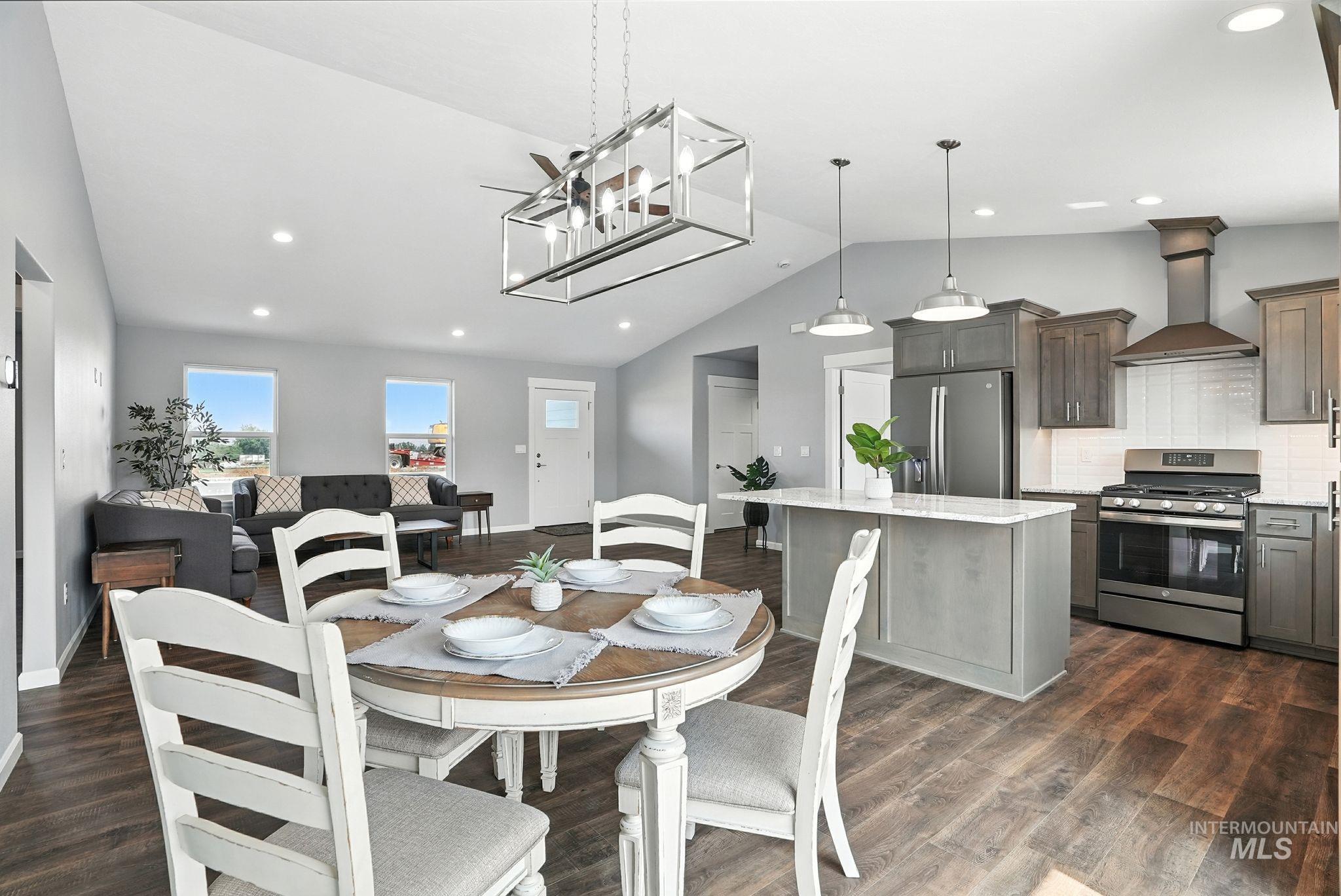 Dining room with dark wood finished floors, recessed lighting, and high vaulted ceiling