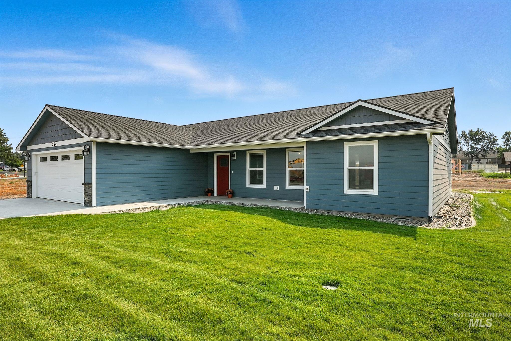 Ranch-style house featuring a shingled roof, a garage, a front yard, and concrete driveway