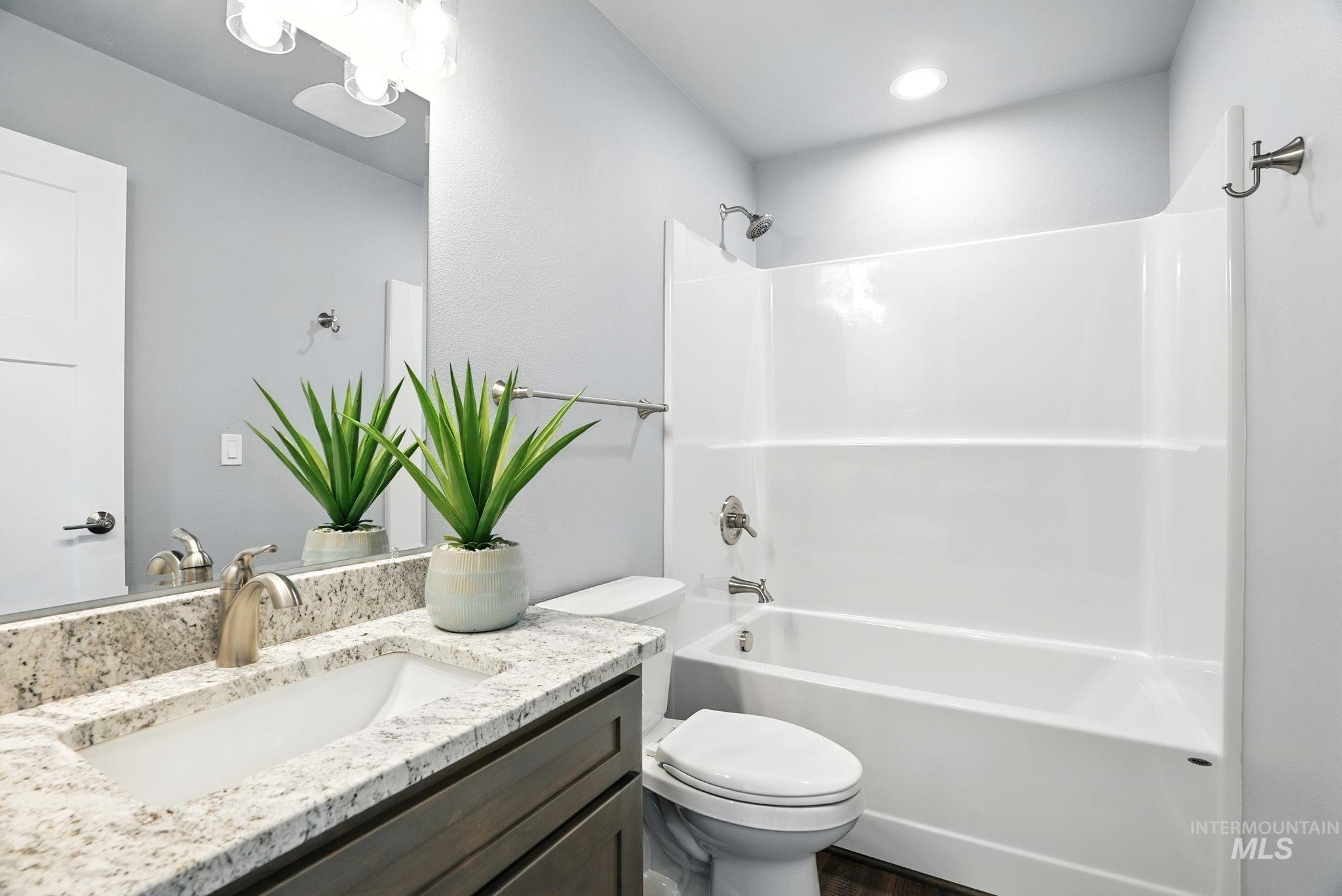 Full bath featuring bathtub / shower combination, vanity, and dark wood-type flooring