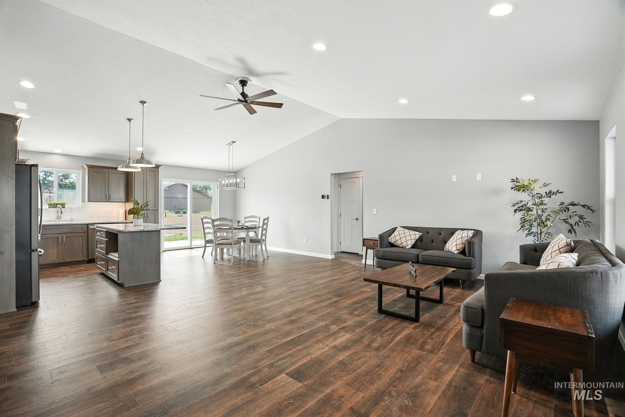 Living area featuring a ceiling fan, recessed lighting, dark wood-type flooring, and high vaulted ceiling
