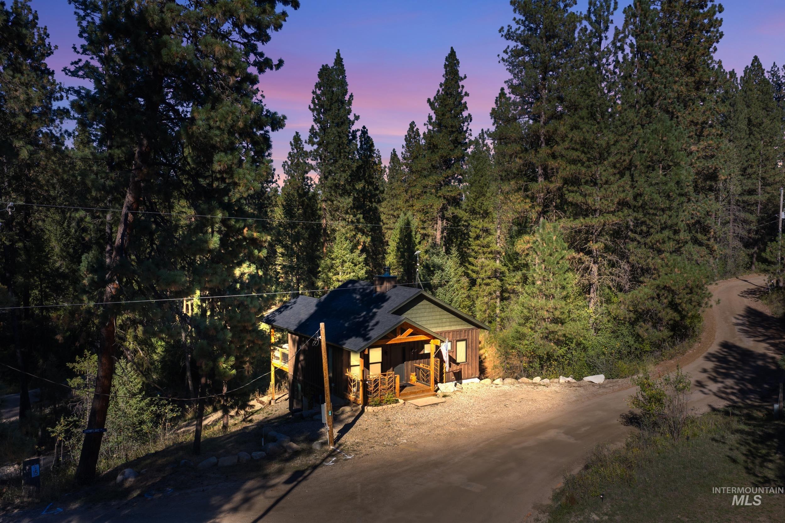 Exterior space with board and batten siding, a view of trees, and driveway