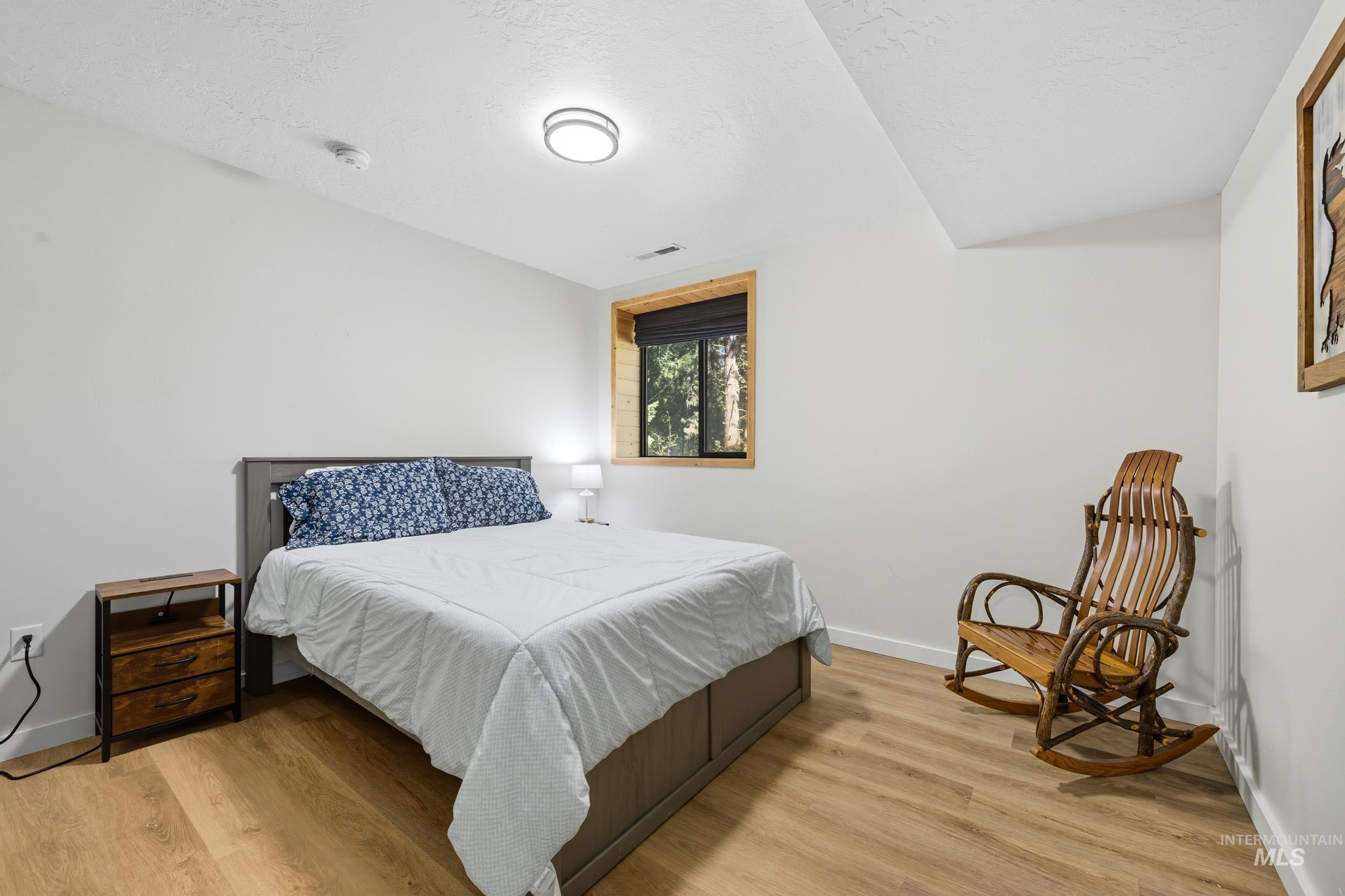 Bedroom featuring light wood-style flooring and a textured ceiling