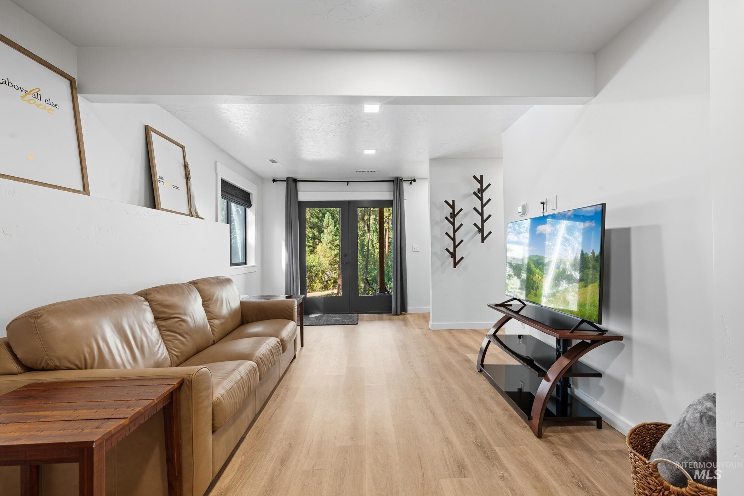 Living area featuring light wood finished floors and french doors