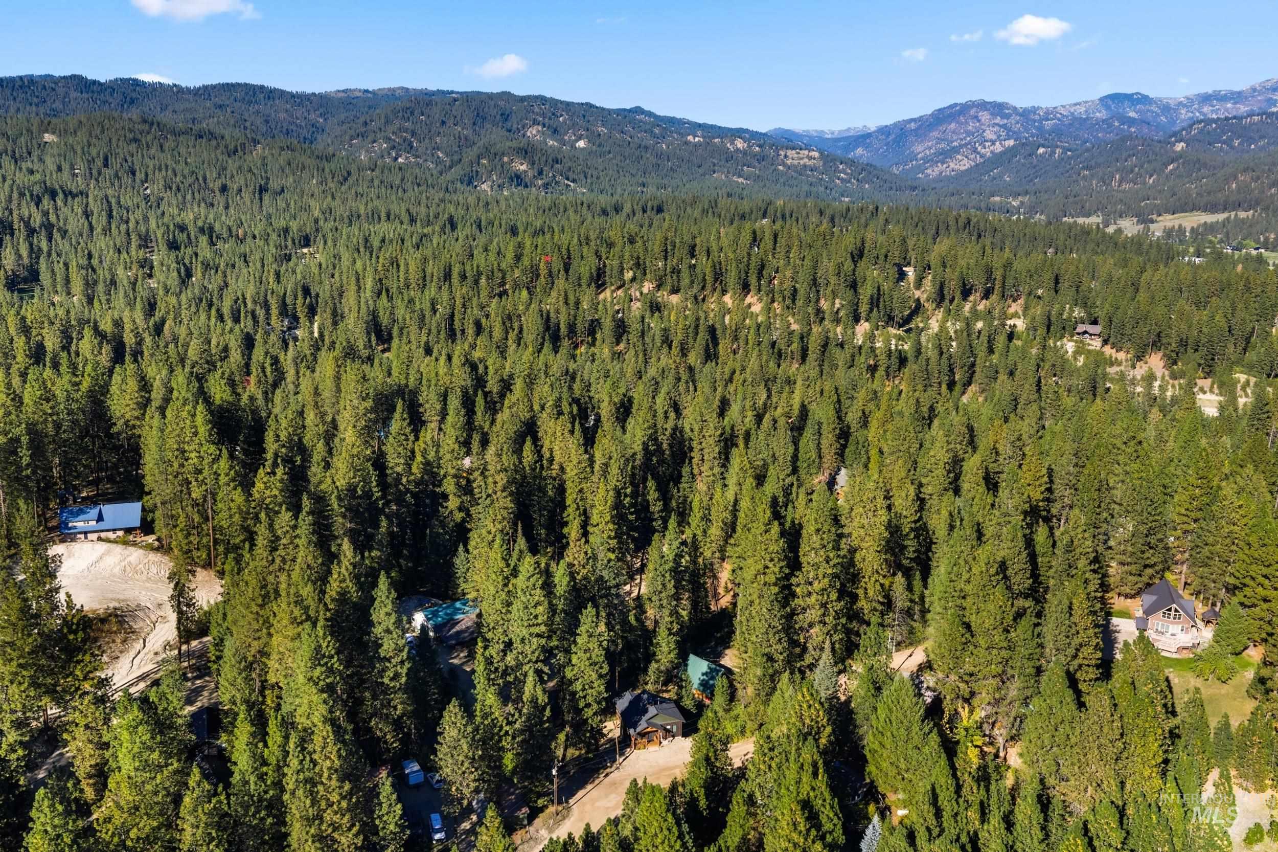 Aerial view of property's location featuring mountains and a forest