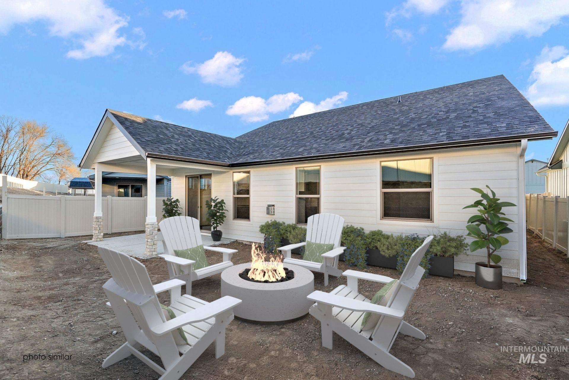 Back of property with a patio, a shingled roof, and an outdoor fire pit