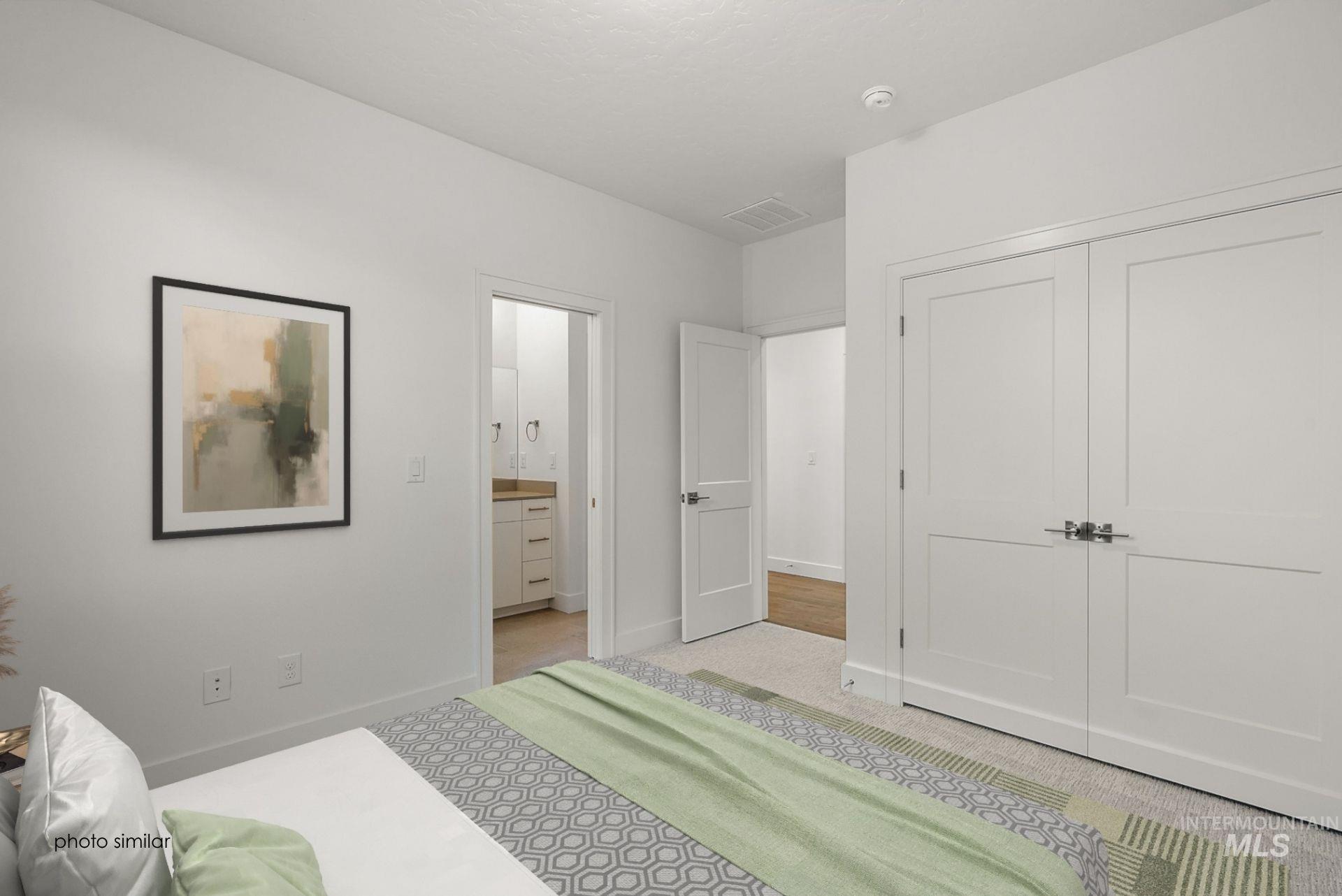 Bedroom featuring light carpet, connected bathroom, and a closet