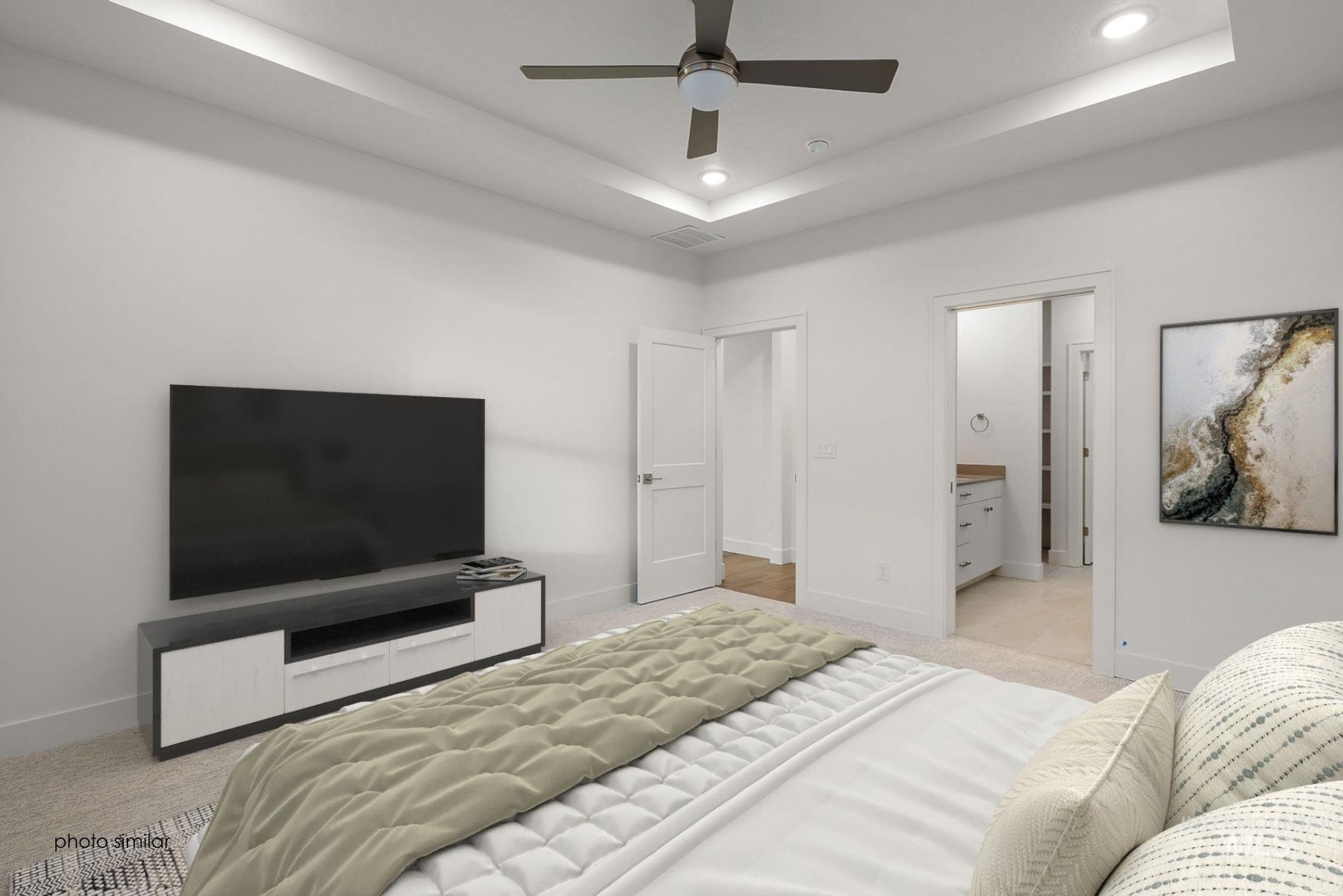 Bedroom with light carpet, a tray ceiling, recessed lighting, and ensuite bath