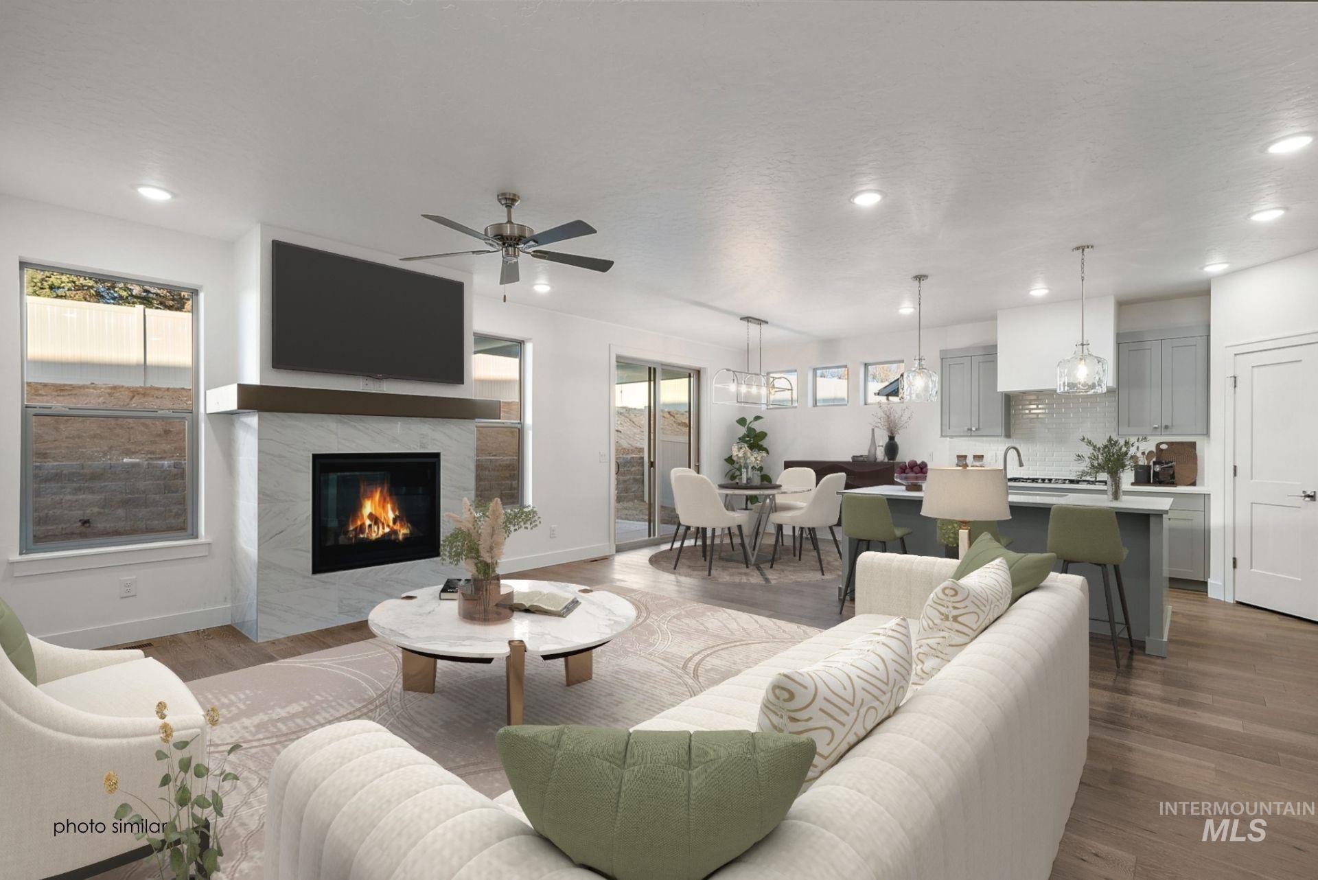 Living area with recessed lighting, dark wood-style flooring, a ceiling fan, and a fireplace