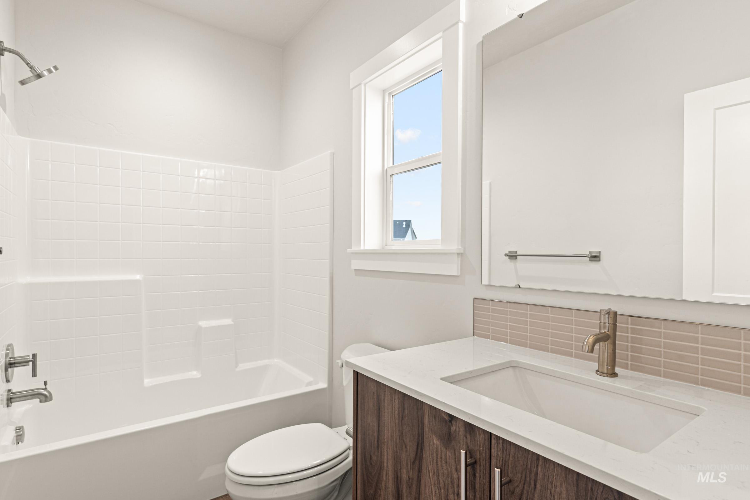 Bathroom vanity with wood-finish cabinetry, white countertop, and integrated sink