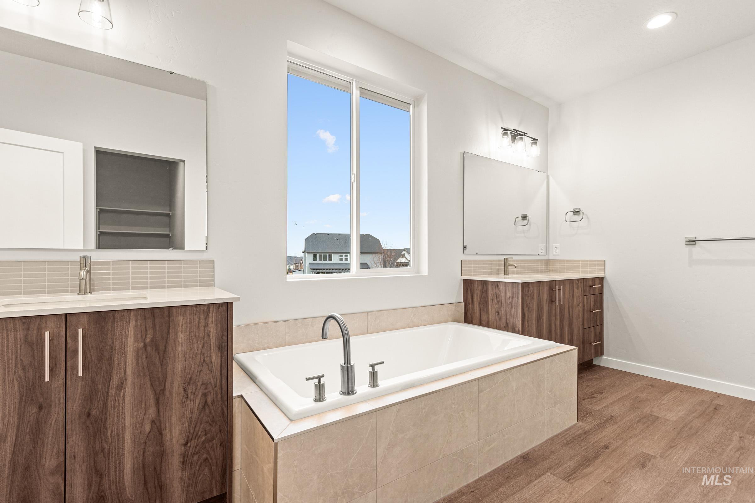 Soaking tub with a contemporary chrome faucet, surrounded by neutral-toned tile