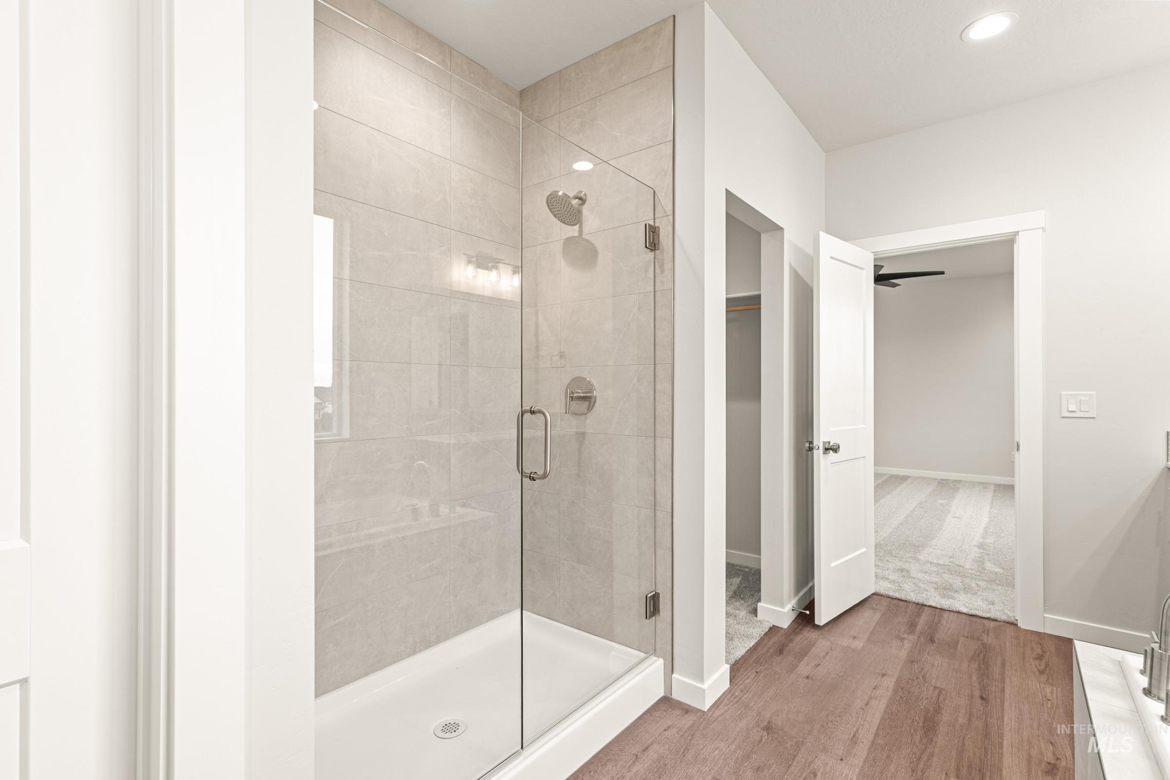 Glass-enclosed shower with tiled walls and a built-in niche