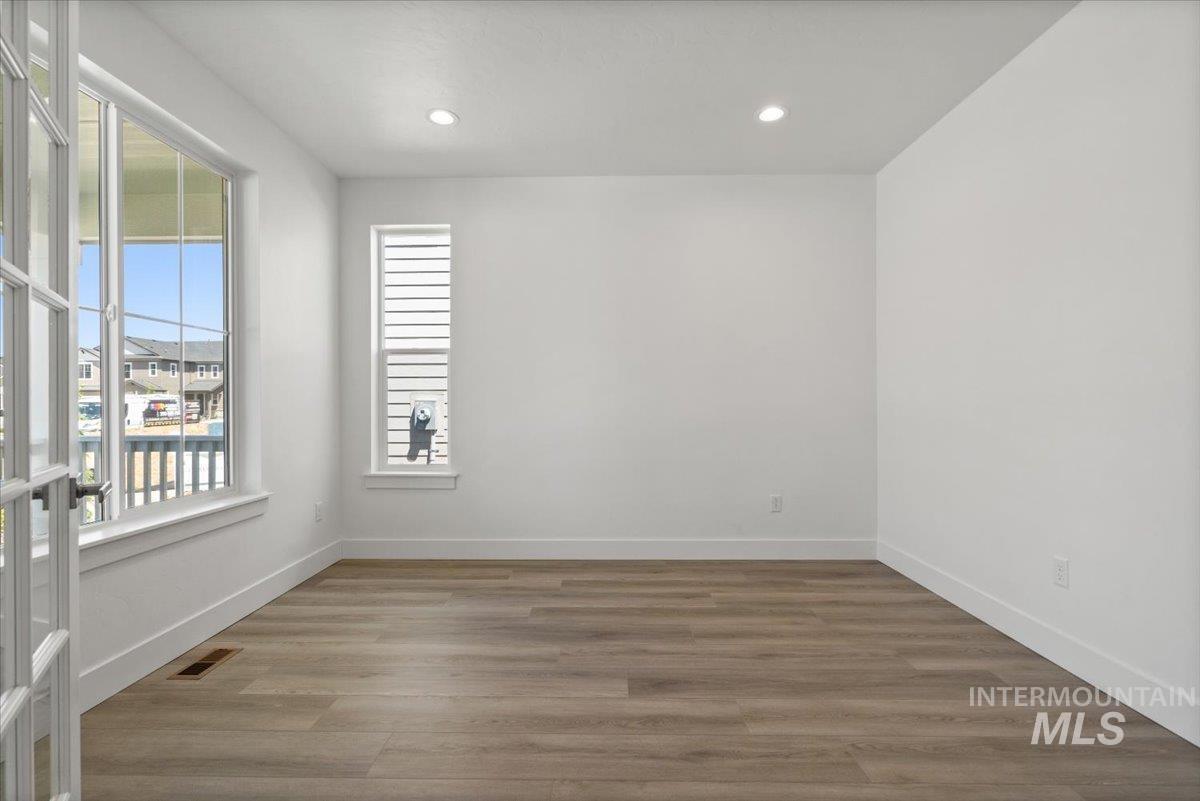 Unfurnished room with wood finished floors and recessed lighting