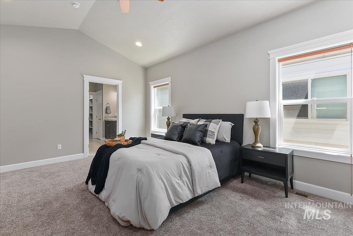 Carpeted bedroom featuring a vaulted ceiling with recessed lighting and a ceiling fan