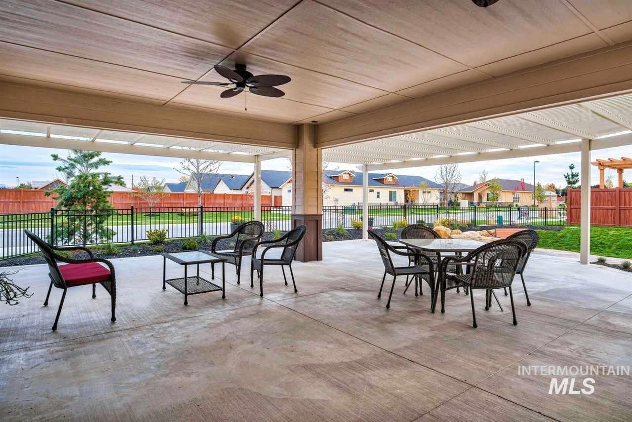 Expansive covered patio featuring a ceiling fan and concrete flooring