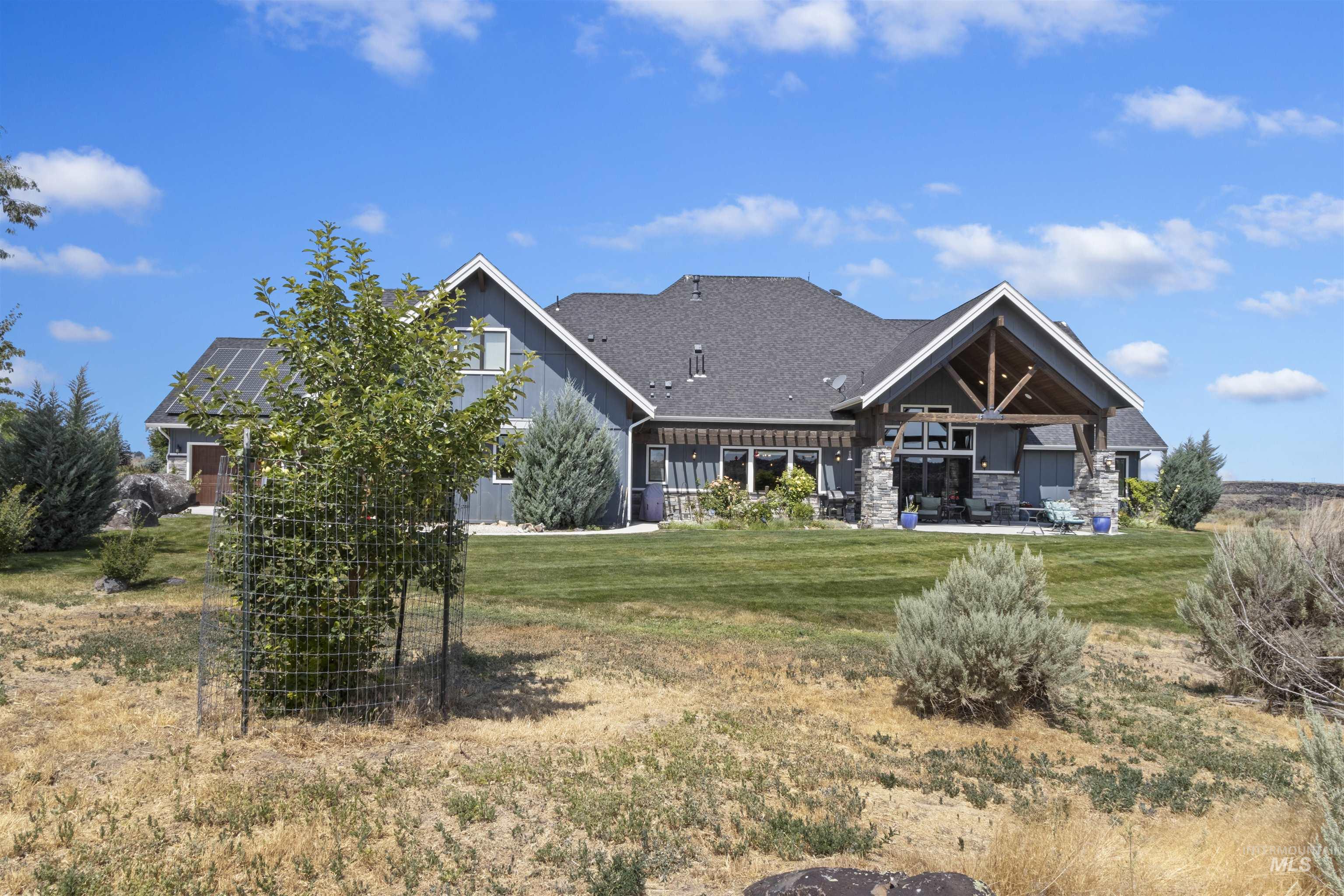 Rear view of property with a lawn, board and batten siding, and a patio