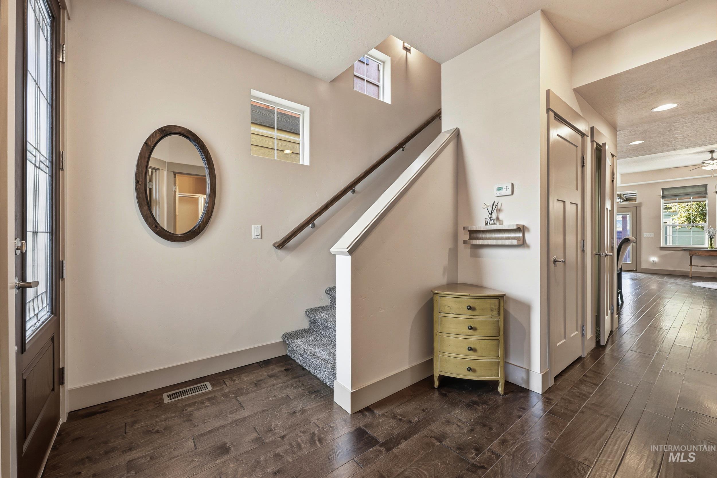 Staircase with wood-type flooring, a ceiling fan, and recessed lighting