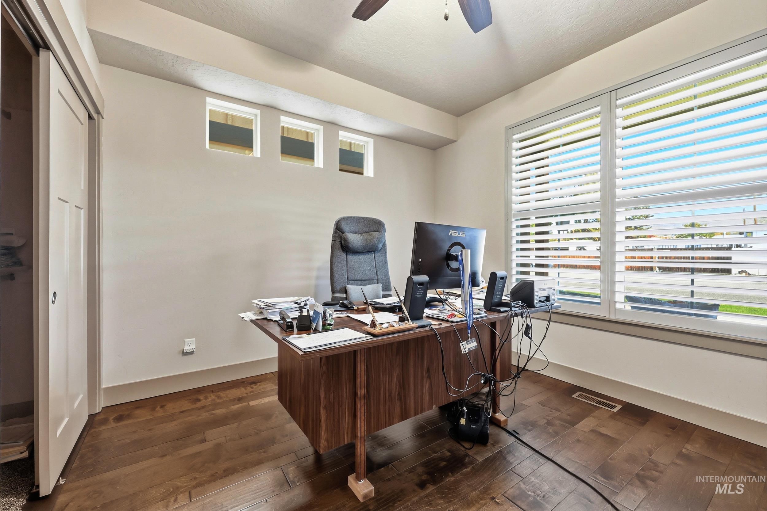 Office area with dark wood finished floors and a ceiling fan