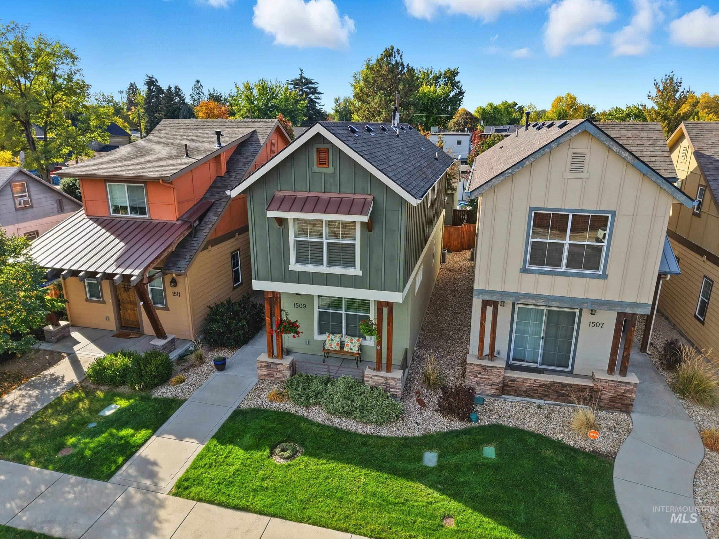 Craftsman-style home featuring board and batten siding, covered porch, a residential view, and a front lawn