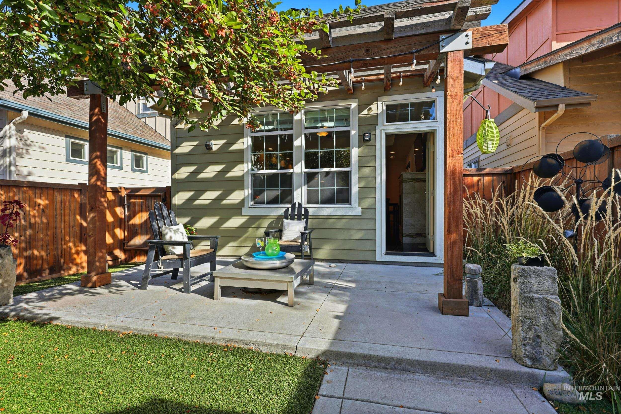 View of exterior entry with a patio area and a pergola