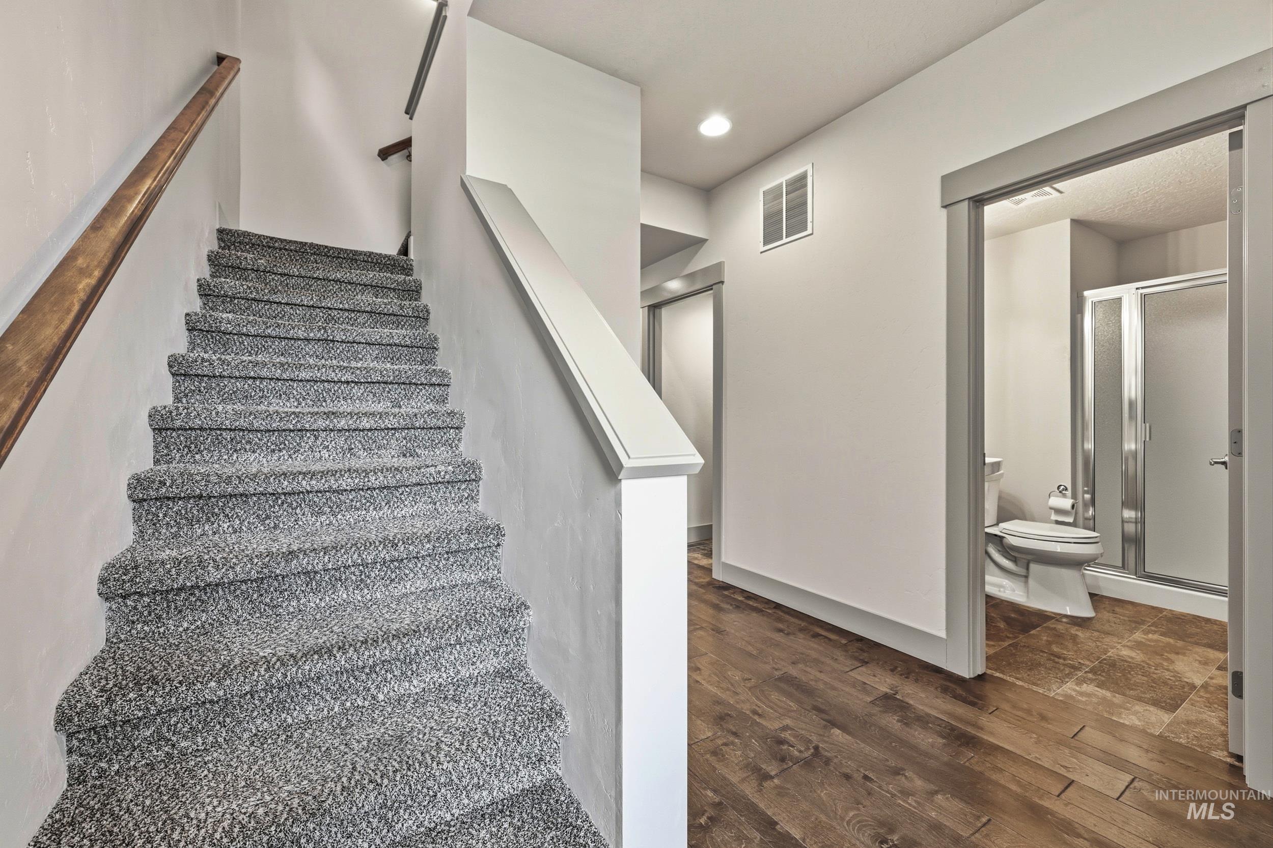 Staircase featuring wood-type flooring and recessed lighting
