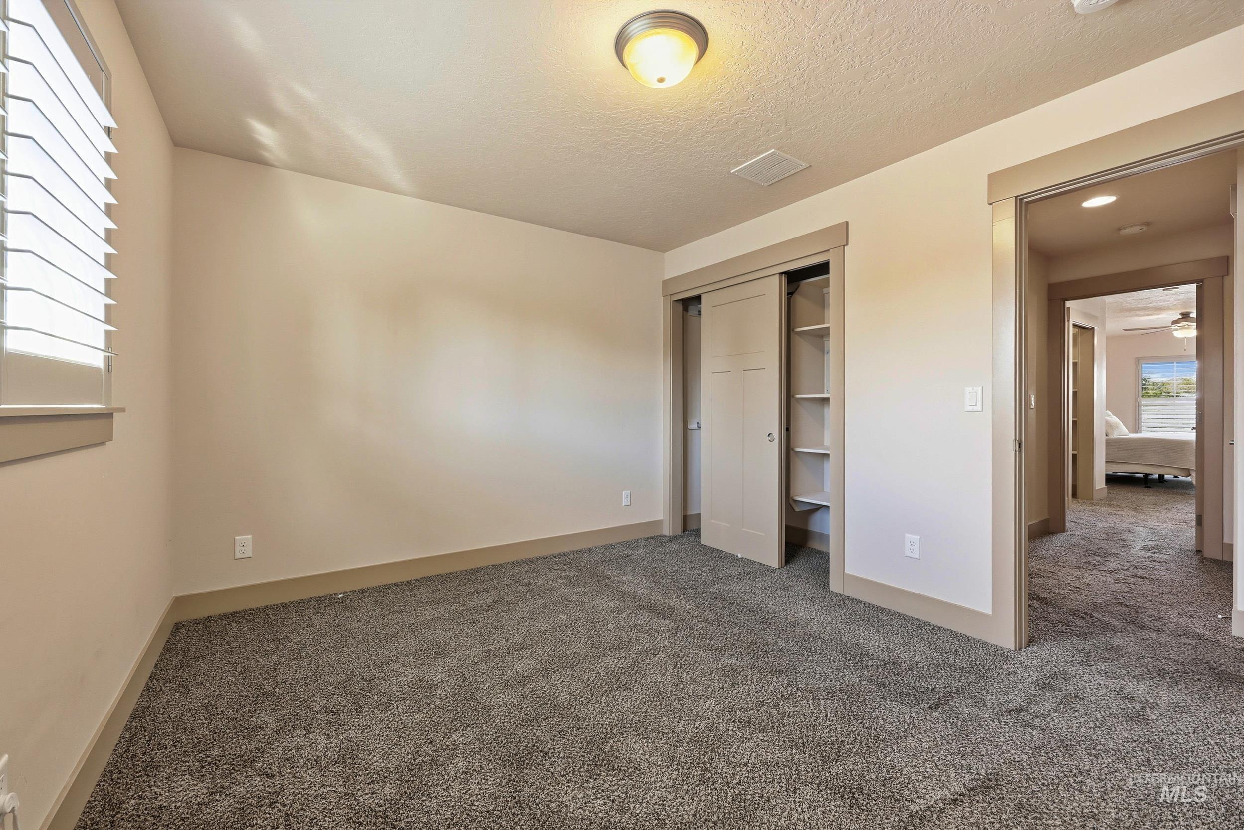 Unfurnished bedroom with carpet flooring, a closet, and a textured ceiling