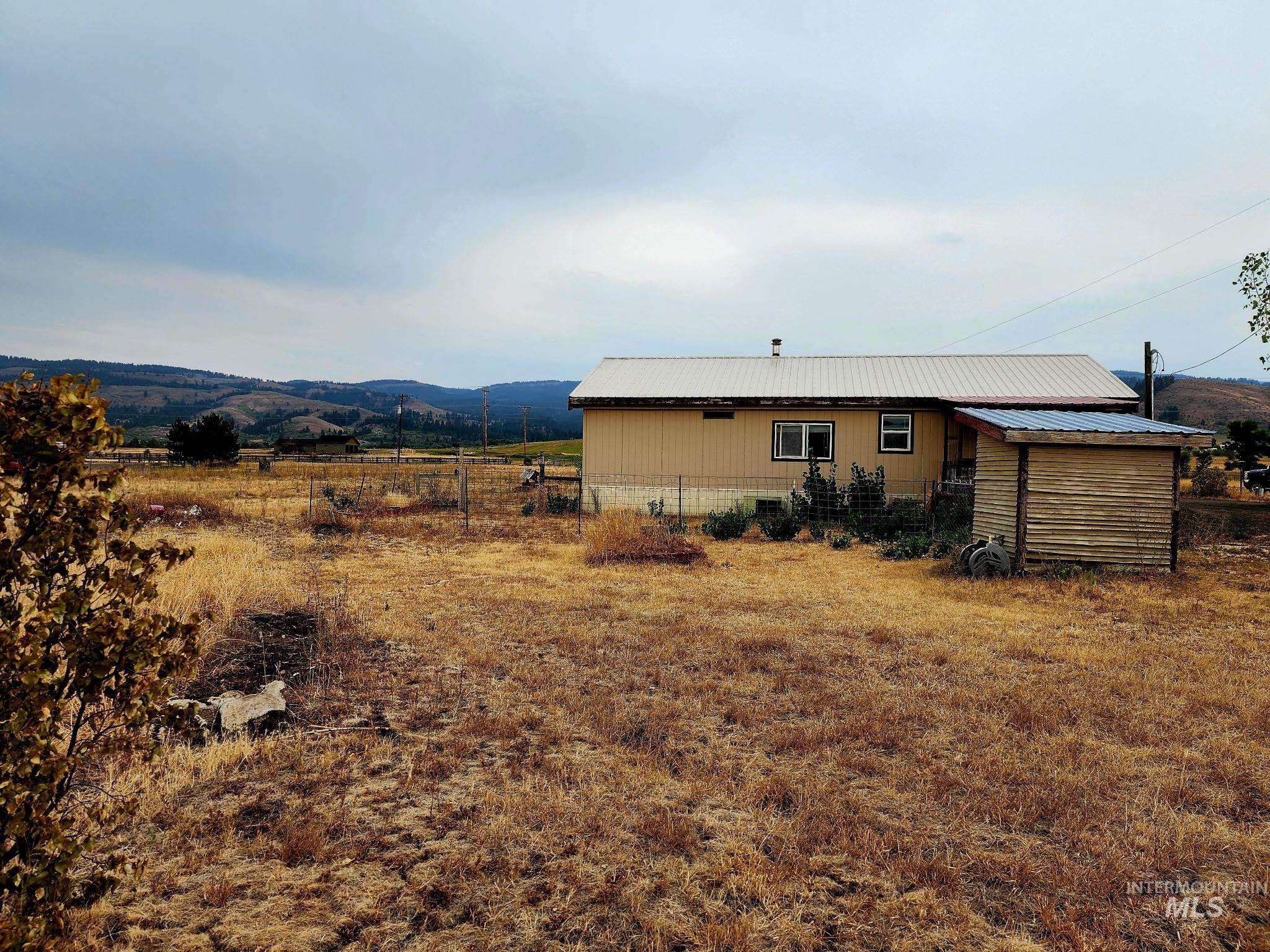 Rear view of property with a metal roof, a mountain view, and a view of countryside