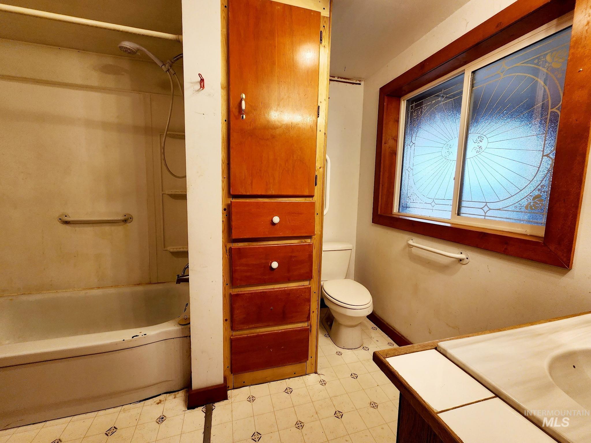 Full bath with vanity, shower / washtub combination.