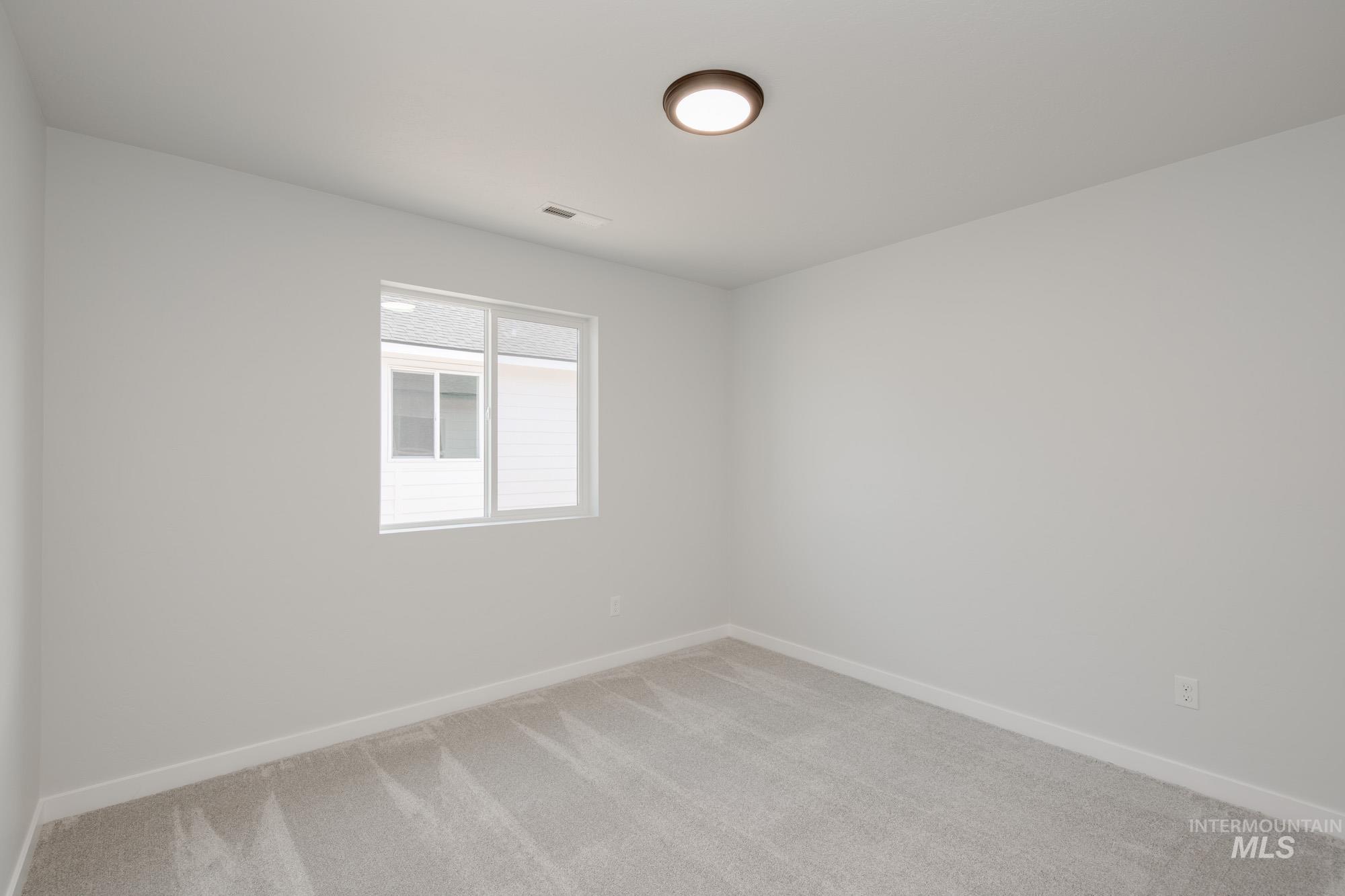 Unfurnished room with light colored carpet and baseboards