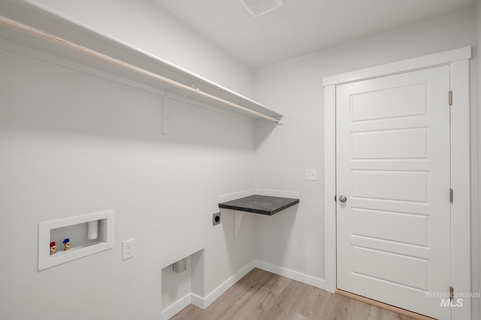 Washroom featuring light wood-style floors, washer hookup, and hookup for an electric dryer