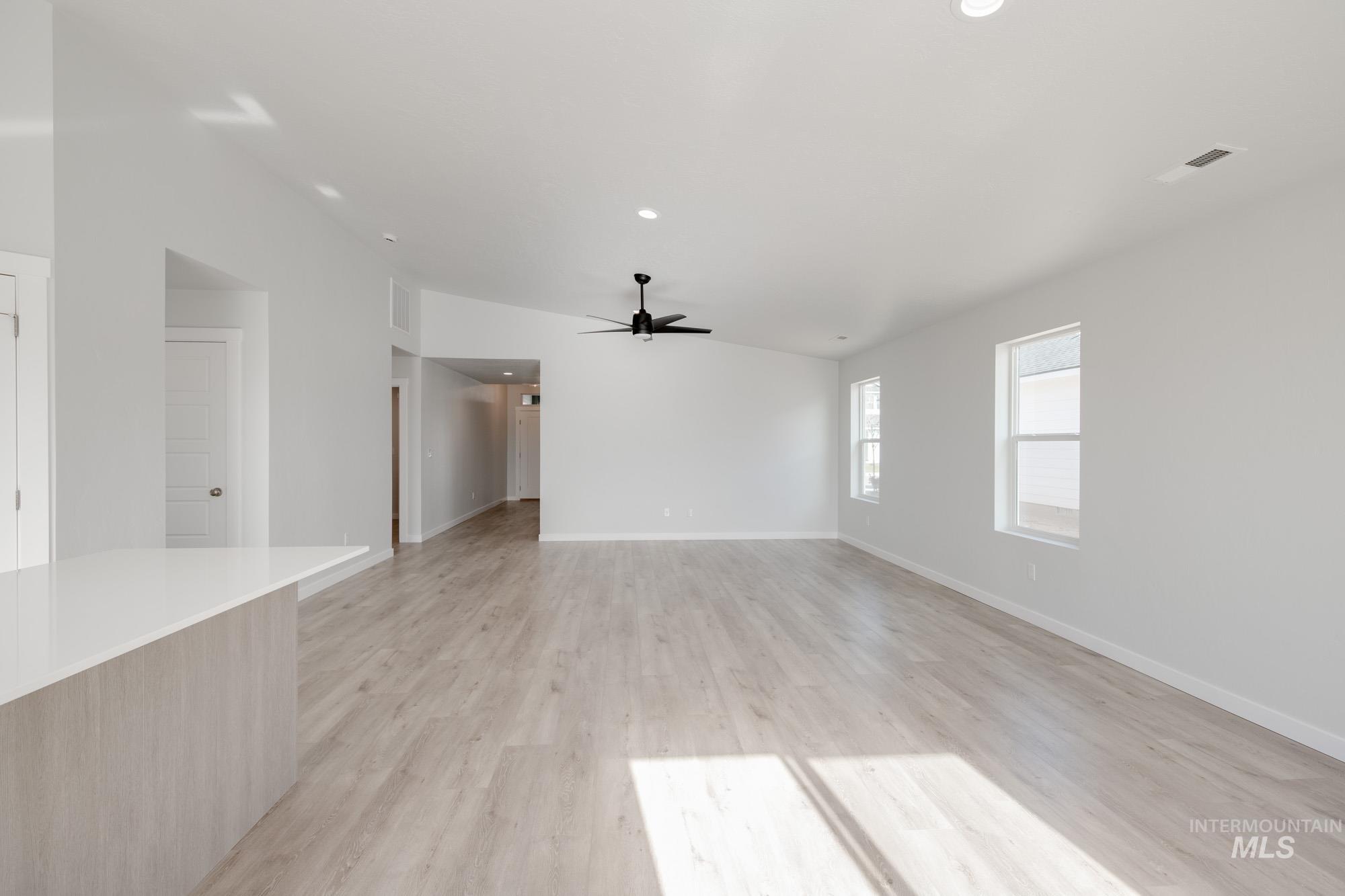 Empty room with light wood-type flooring, recessed lighting, a ceiling fan, and vaulted ceiling