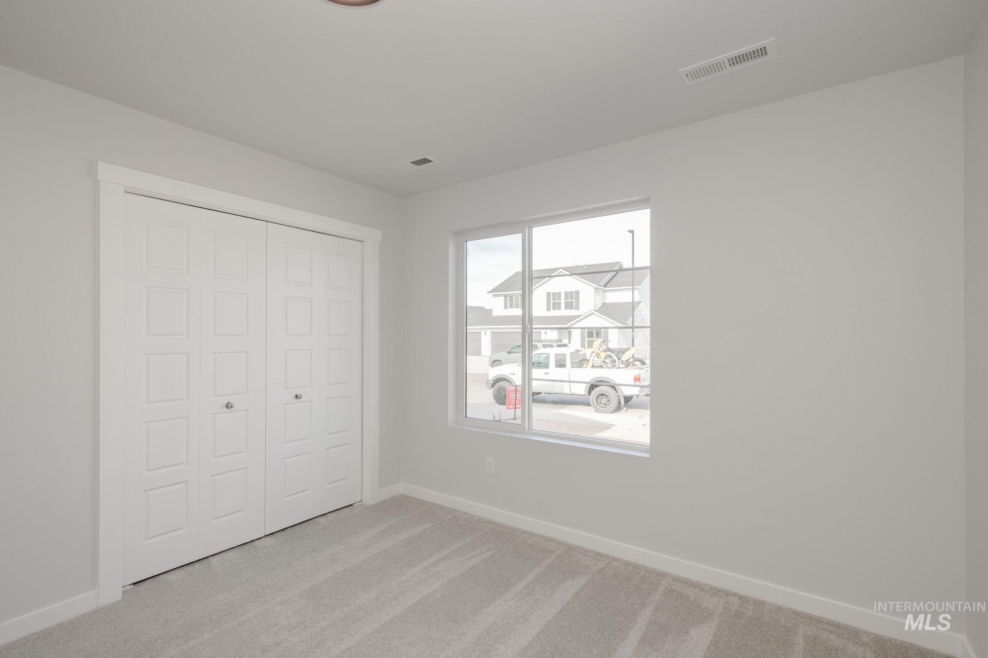 Unfurnished bedroom featuring light colored carpet and a closet