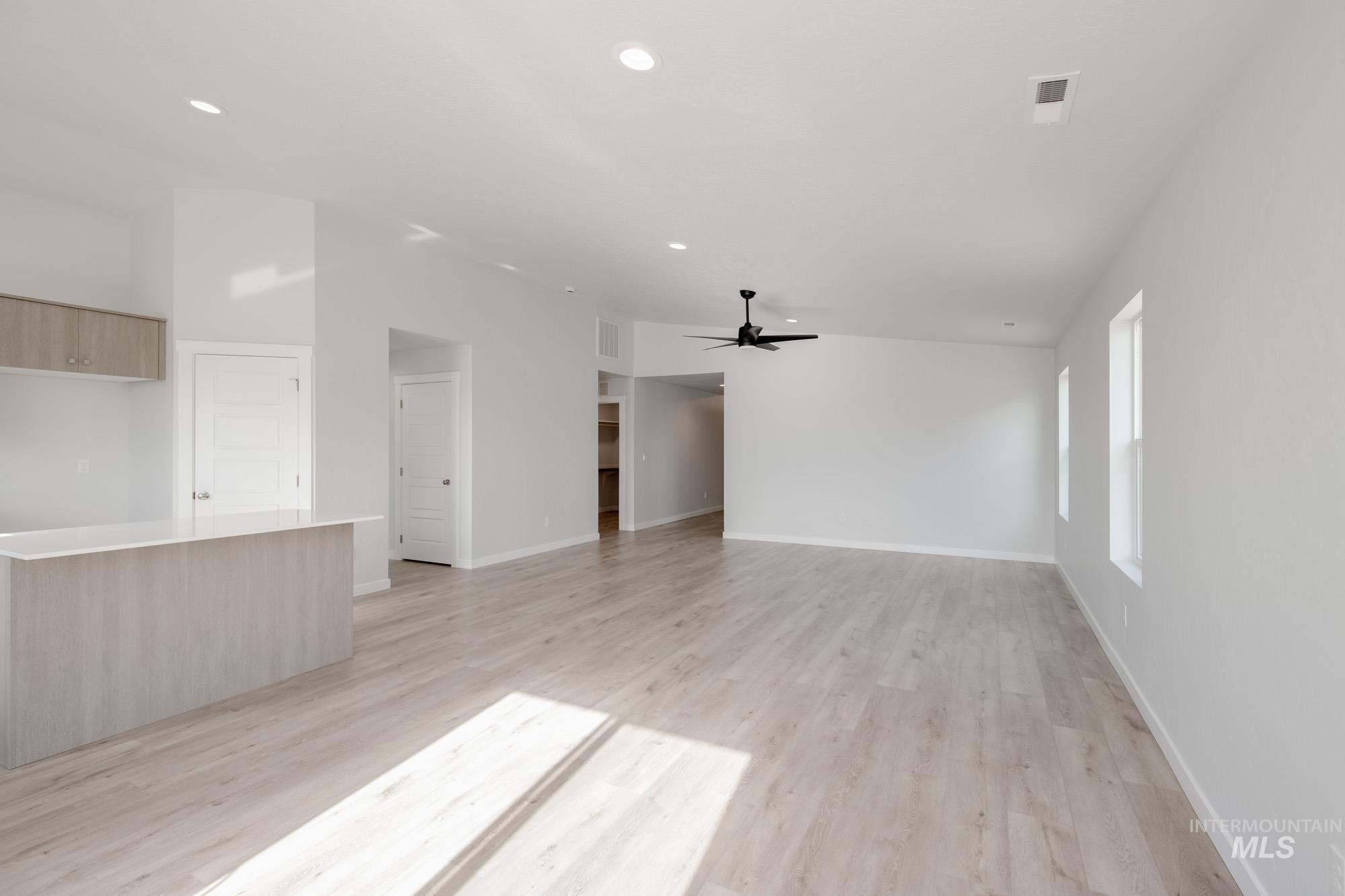 Unfurnished living room with light wood finished floors, ceiling fan, and recessed lighting