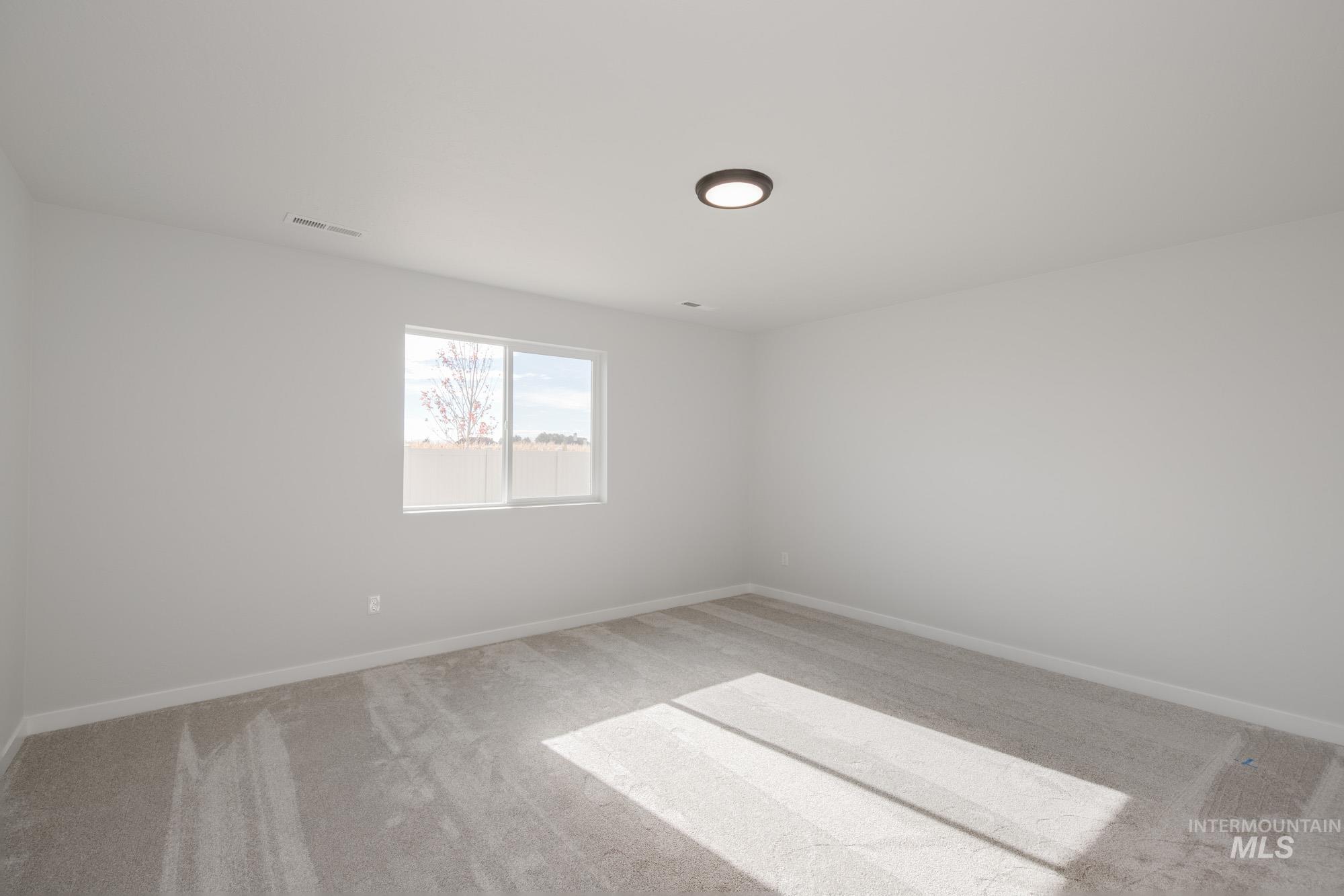 Unfurnished room with light colored carpet and baseboards