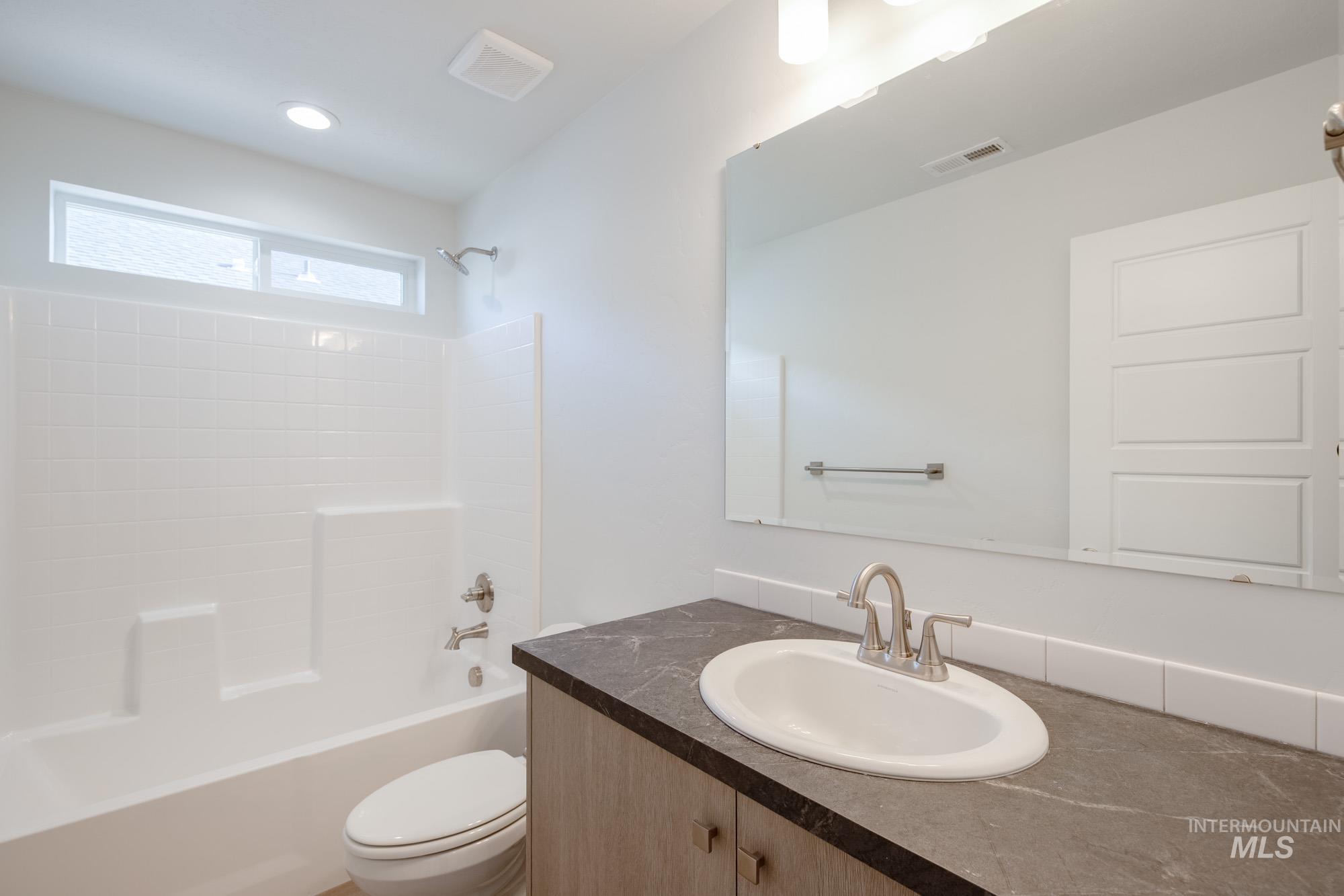 Full bath featuring  shower combination, vanity, and recessed lighting