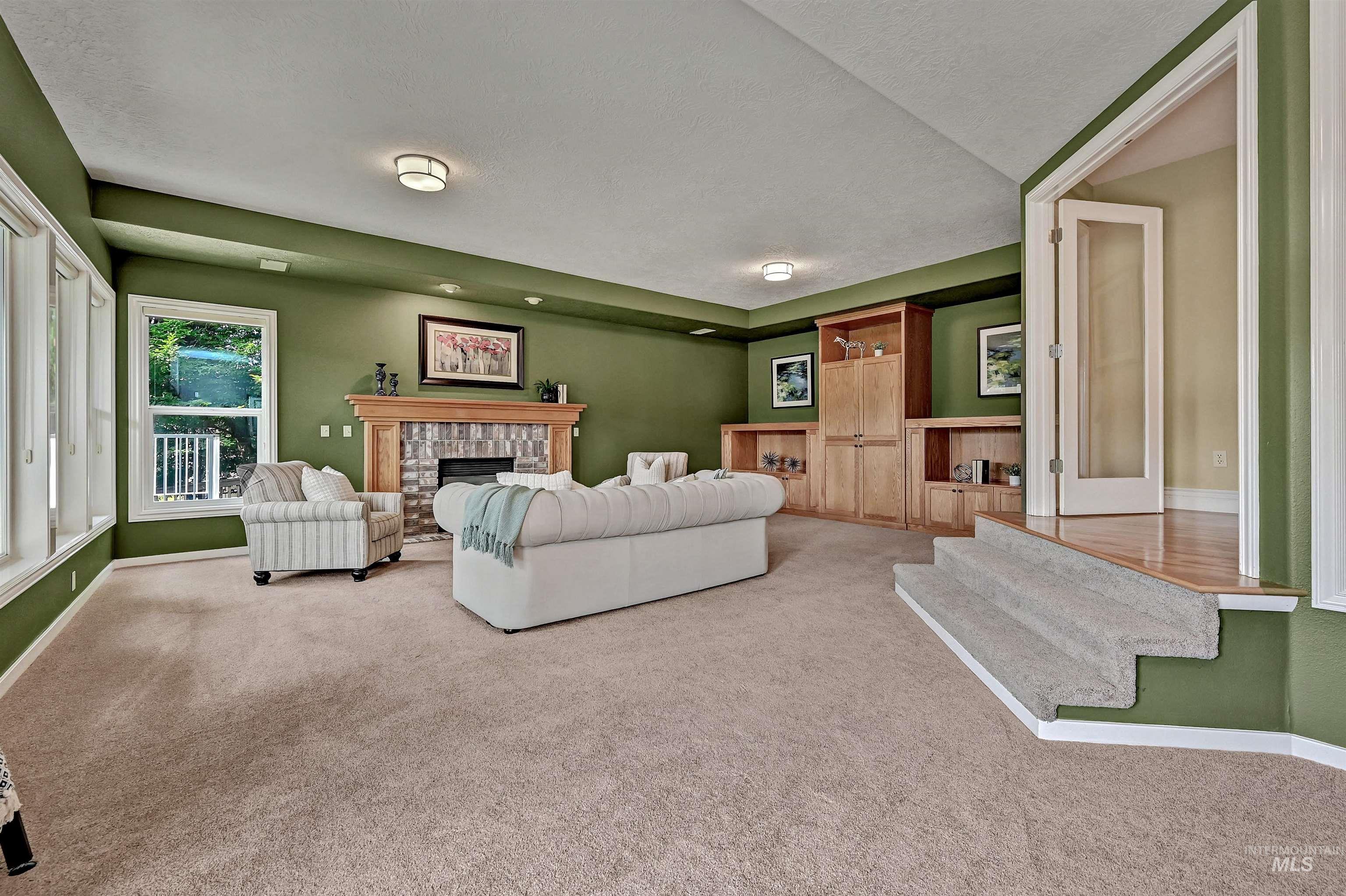 Carpeted living room featuring a fireplace and a textured ceiling