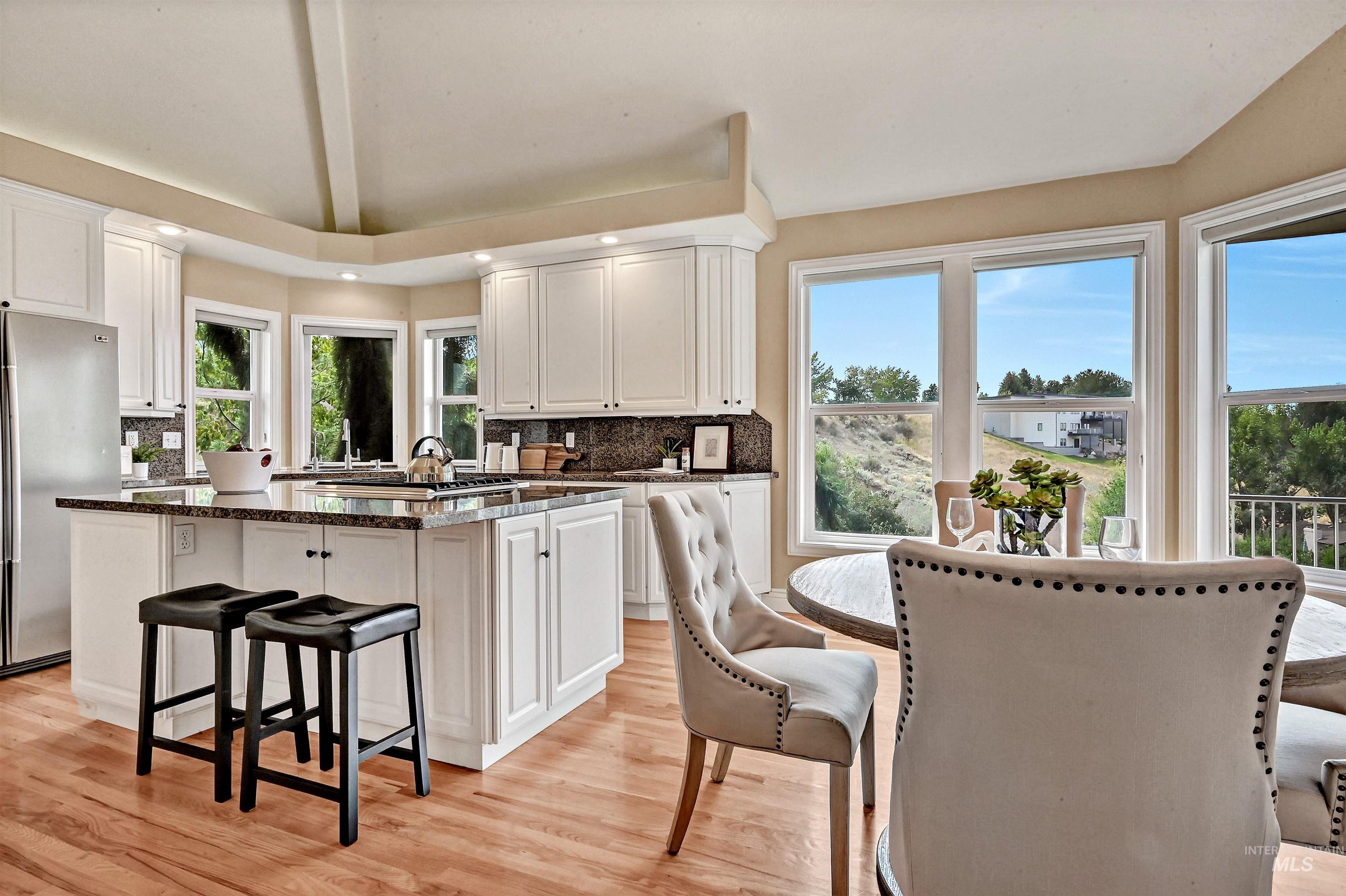 Kitchen featuring a kitchen island, a breakfast bar, white cabinets, freestanding refrigerator, and backsplash