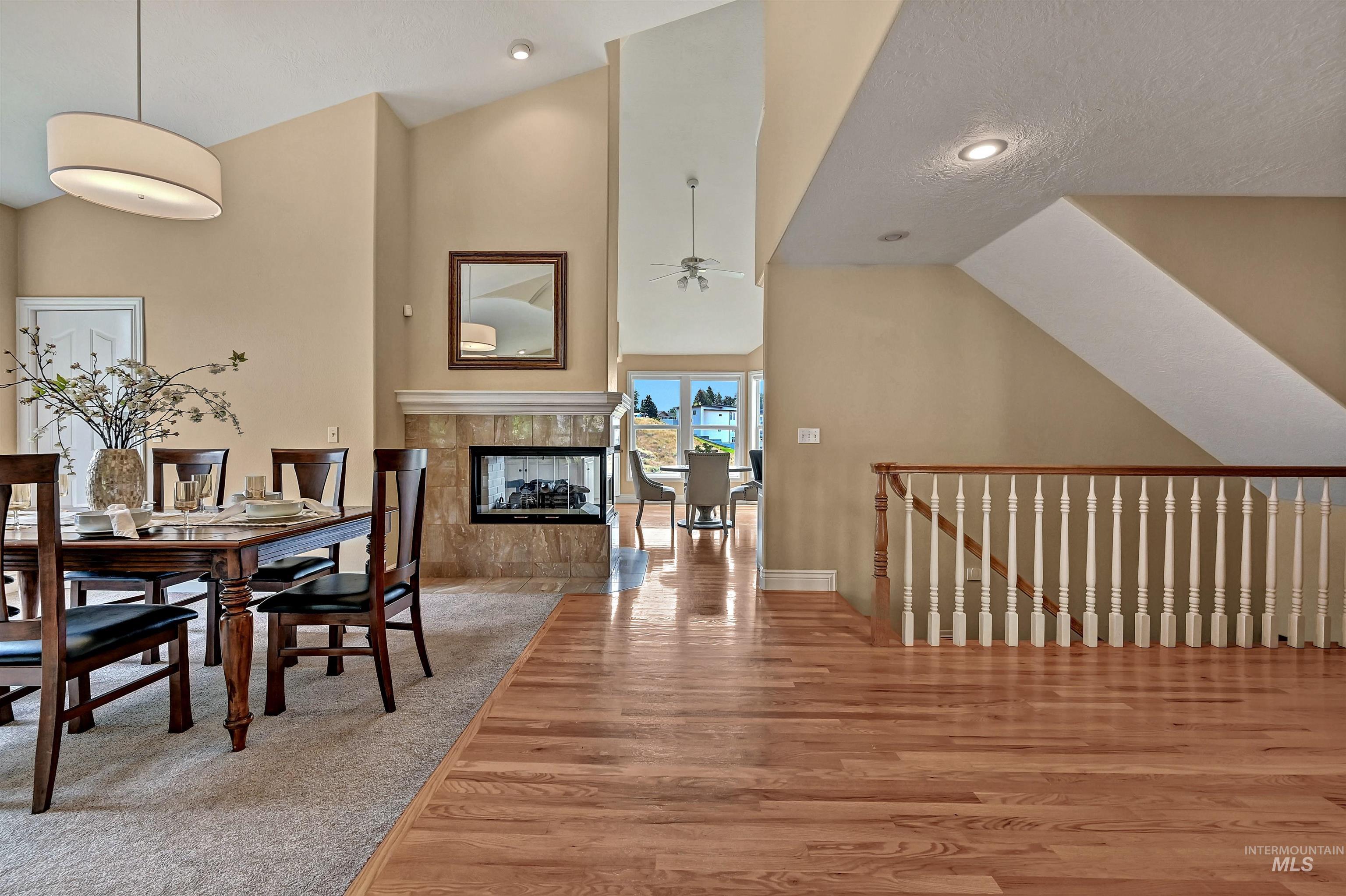 Dining room with a fireplace, light wood-type flooring, ceiling fan, a textured ceiling, and recessed lighting