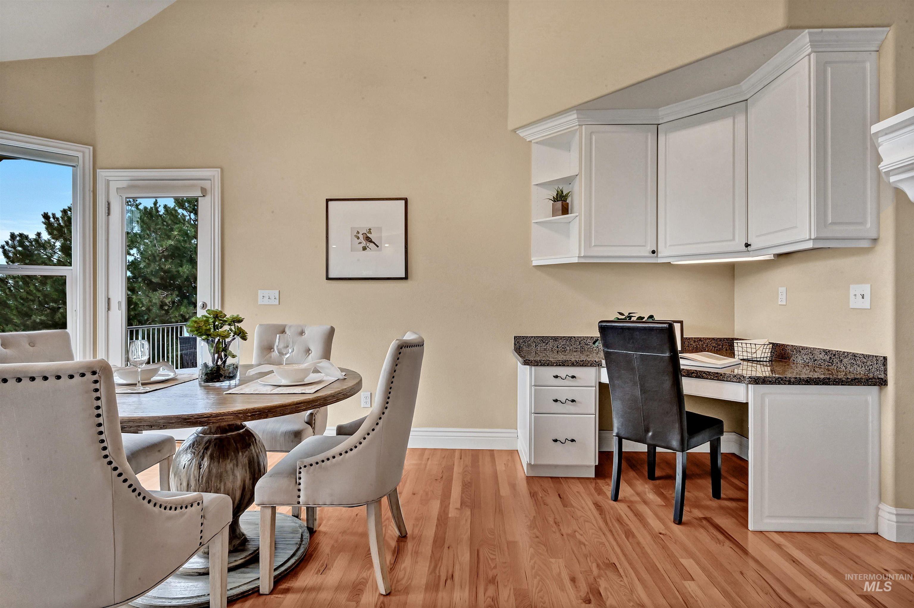 light wood-style floors, high vaulted ceiling, and built in study area