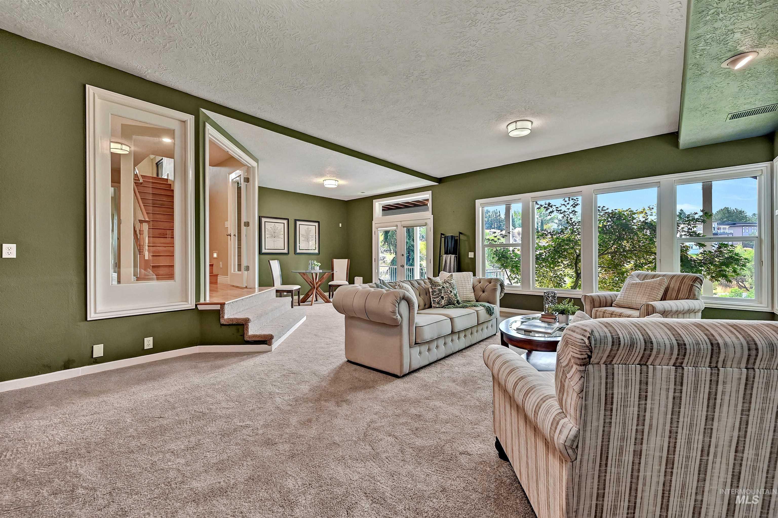 Carpeted living area with a textured ceiling and baseboards