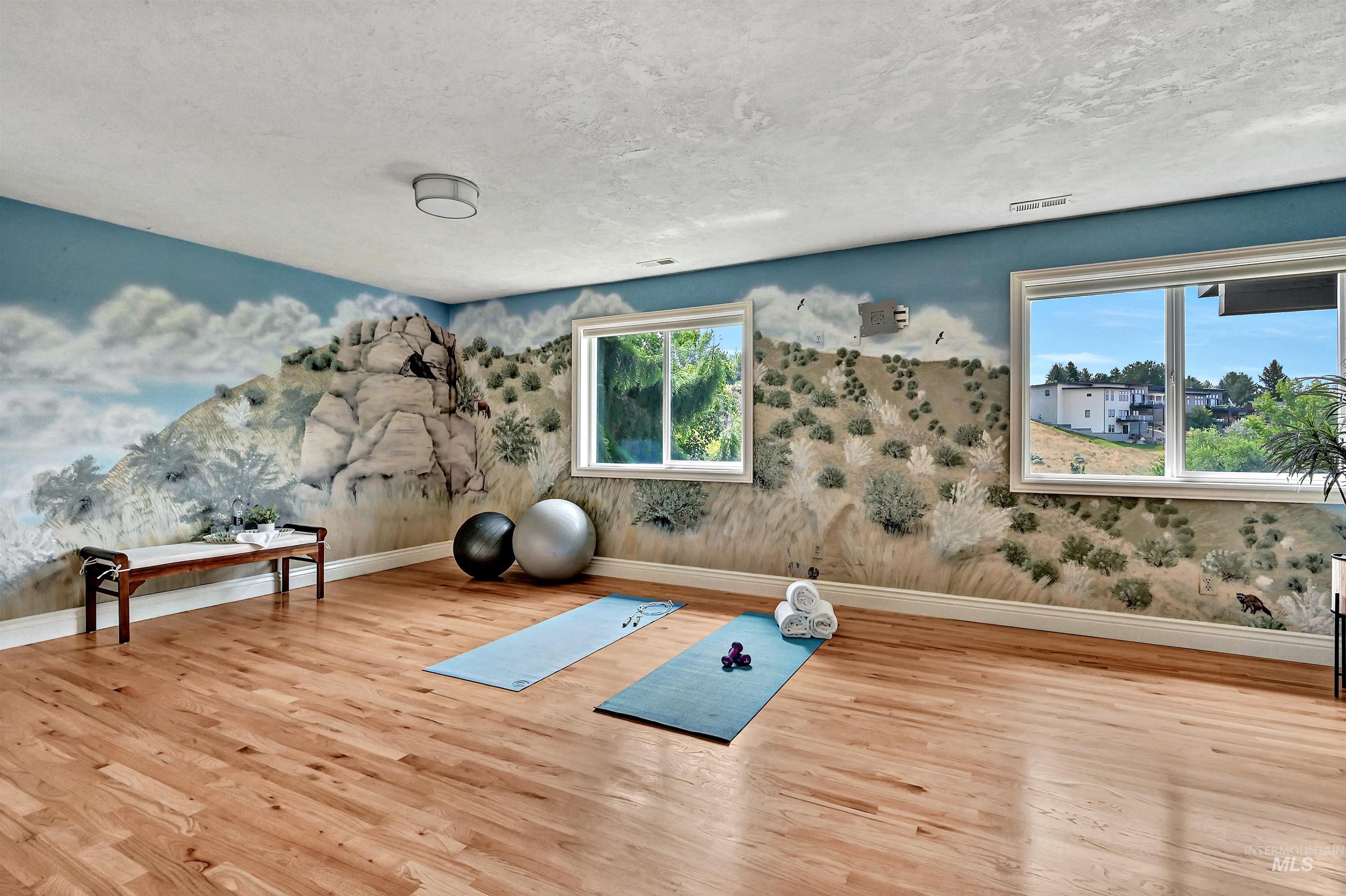 Exercise room with wood finished floors and a textured ceiling