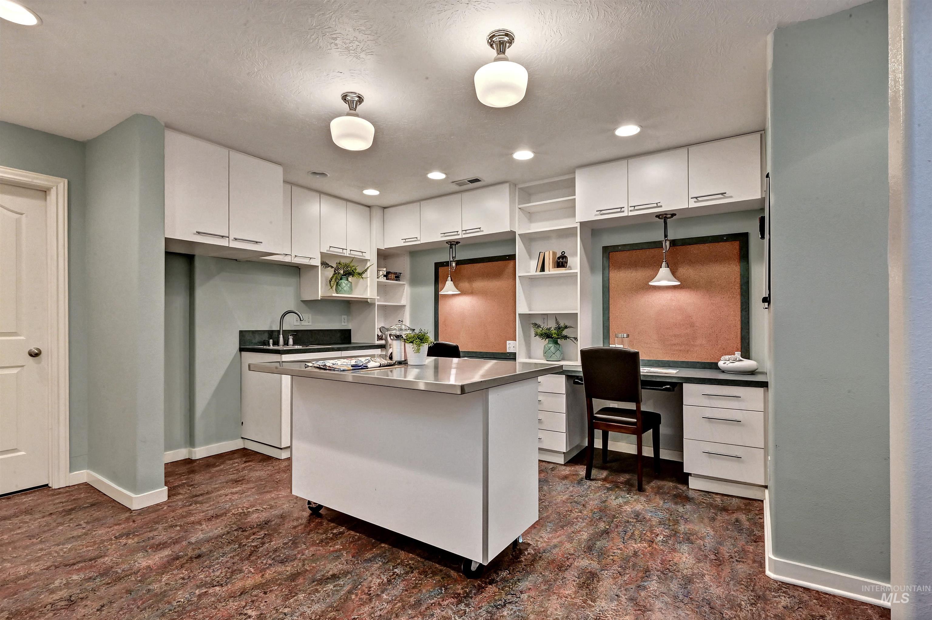 Kitchen featuring white cabinetry, a center island, recessed lighting, open shelves, and stainless steel countertops