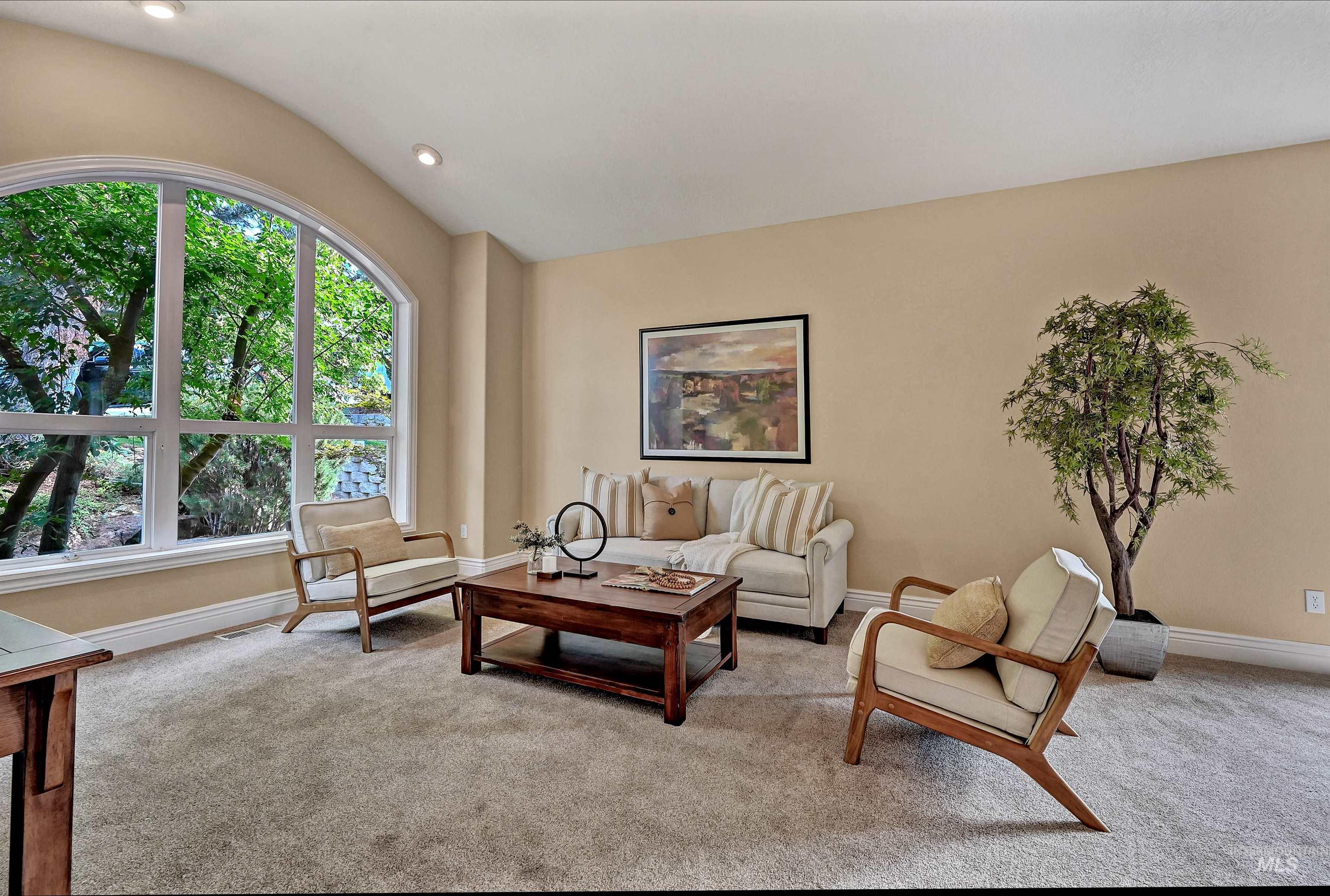 Carpeted living area with lofted ceiling and recessed lighting
