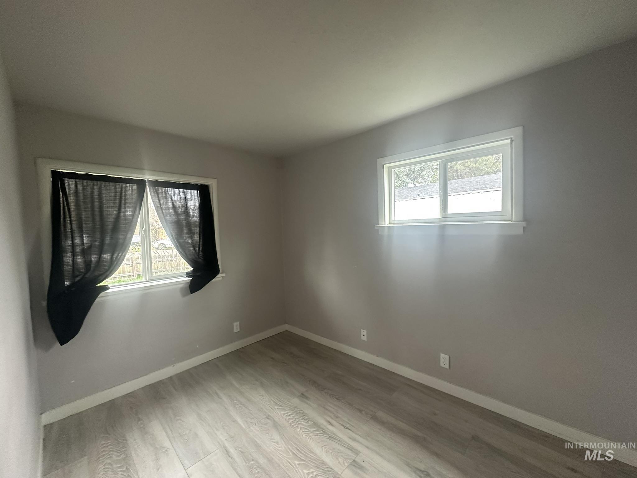Unfurnished room with light wood finished floors and healthy amount of natural light